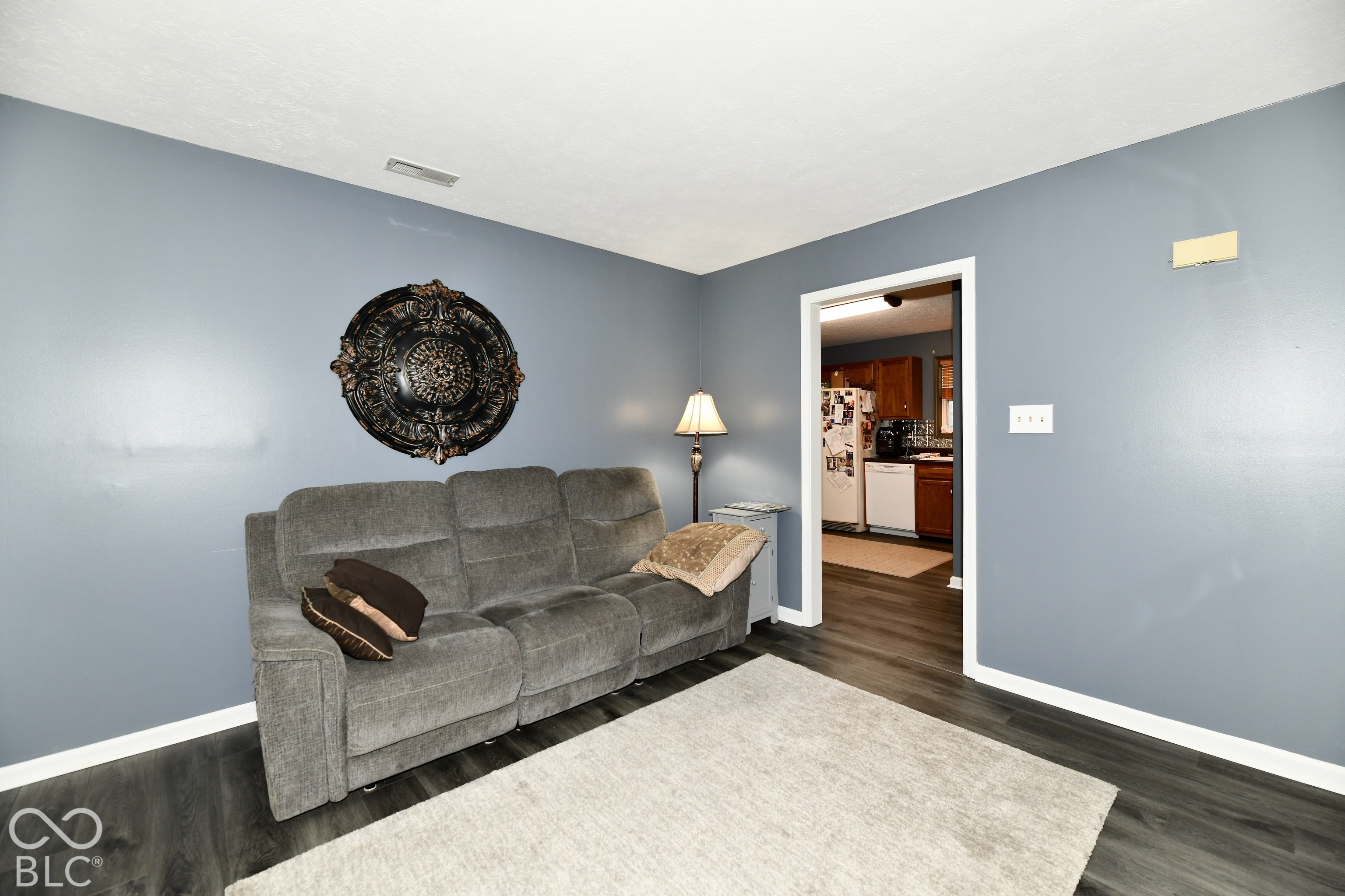 Interior room featuring dark-toned wood-finish flooring and solid-color wall paint