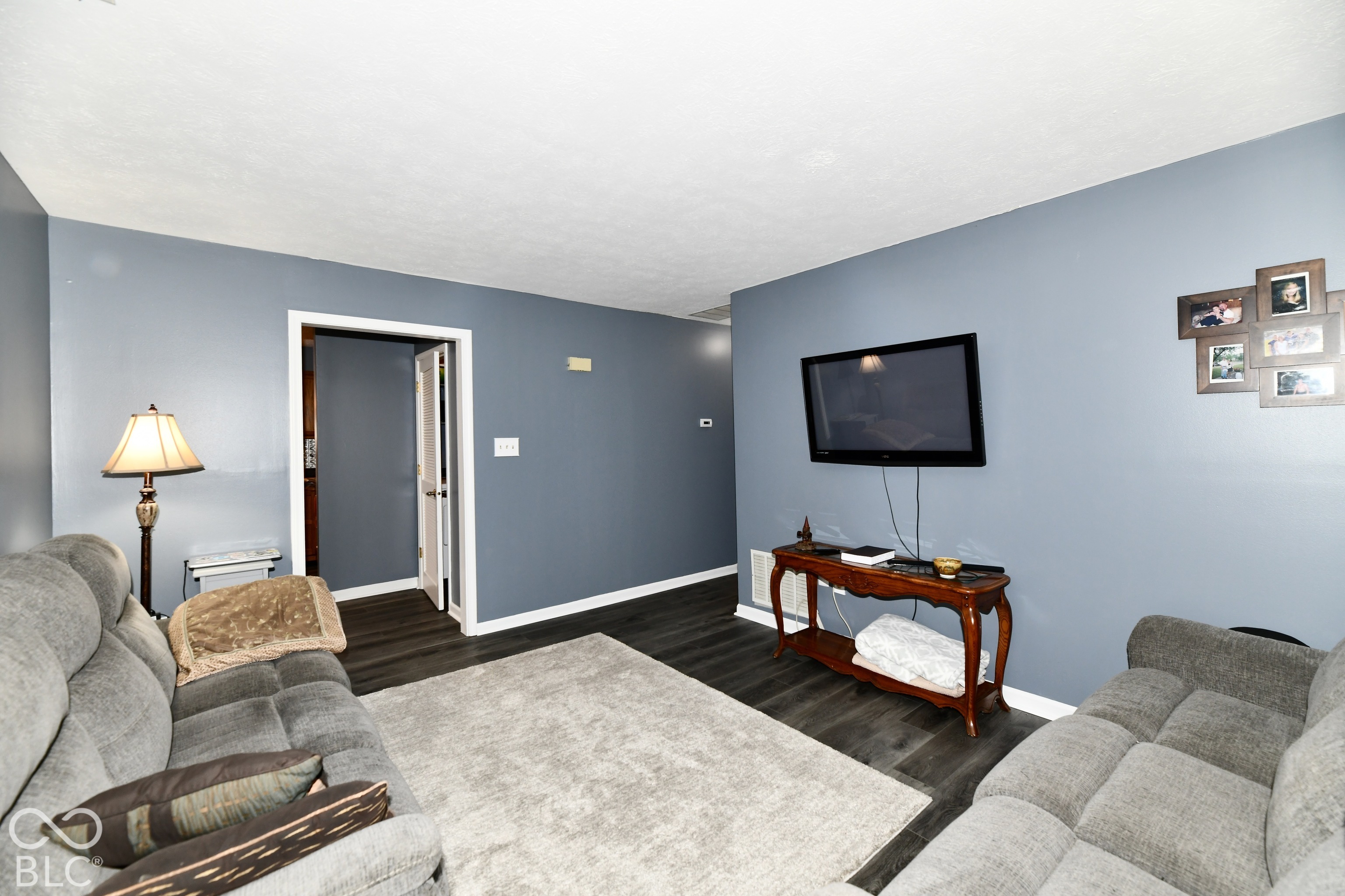 Living room featuring dark-tone wood-finish flooring and neutral wall paint