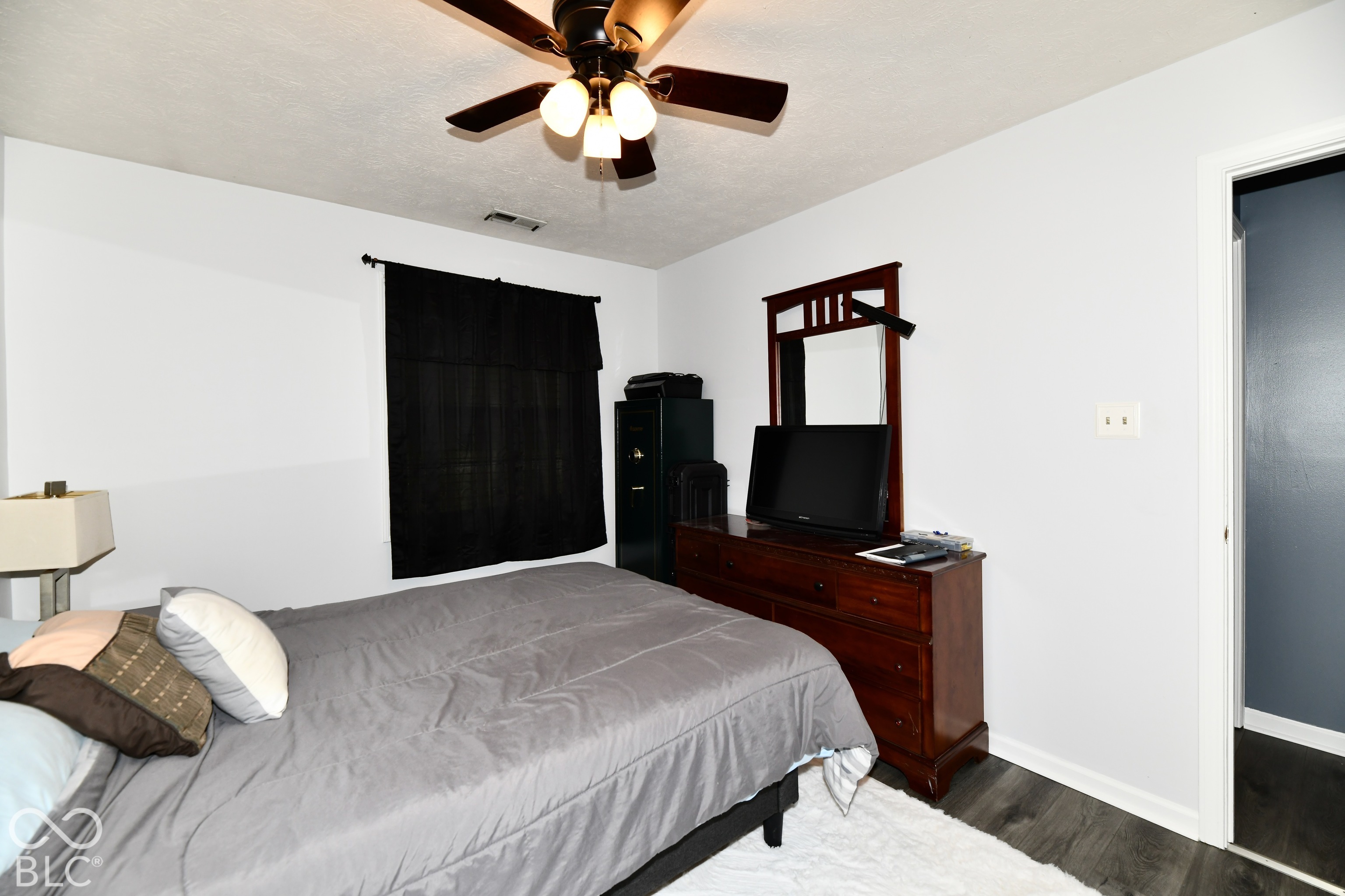 Room featuring wood-finish flooring, a ceiling fan with integrated lighting, and a single-window configuration