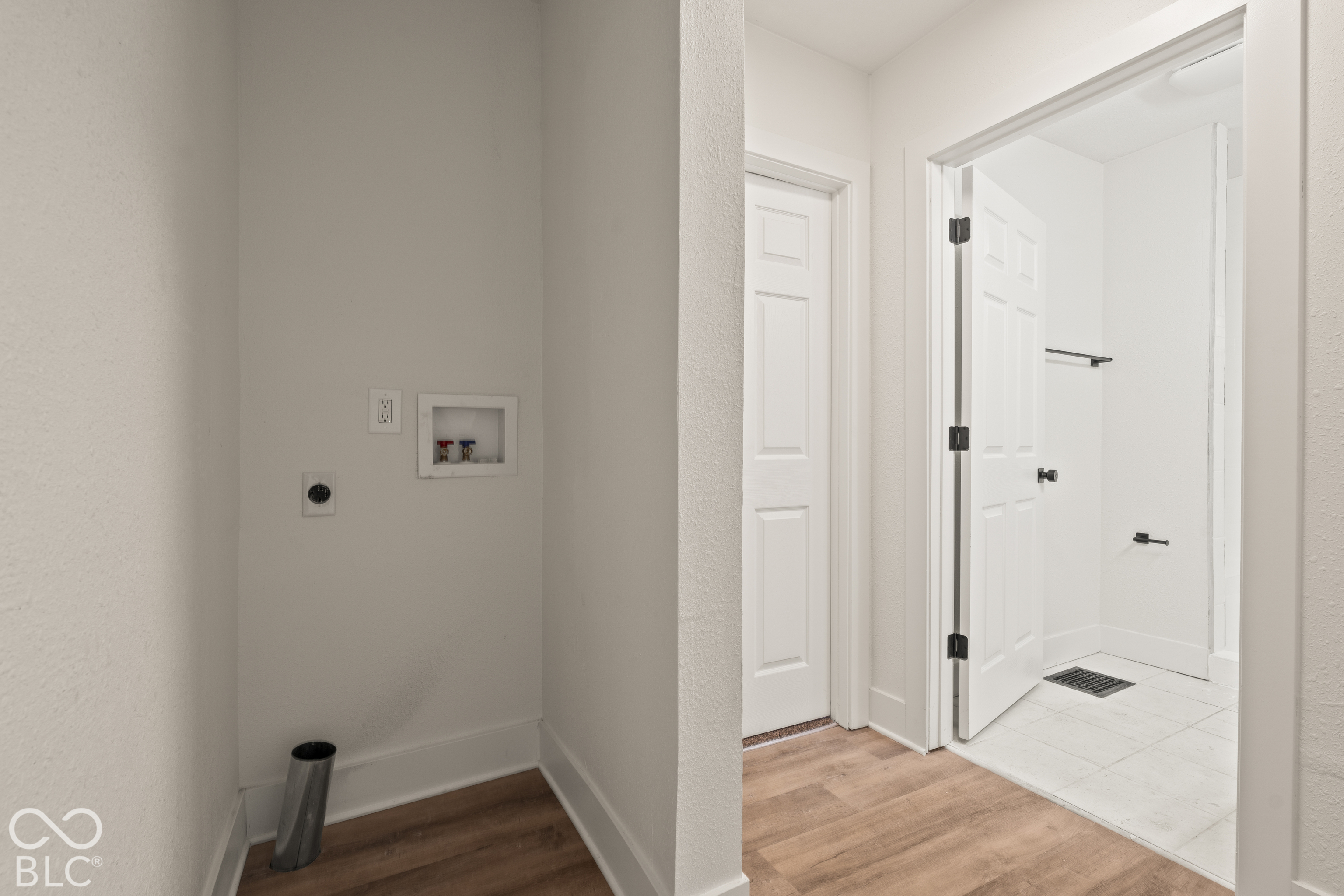 Utility area featuring laundry hookups, wood-finish flooring, two-panel interior doors, and tile flooring
