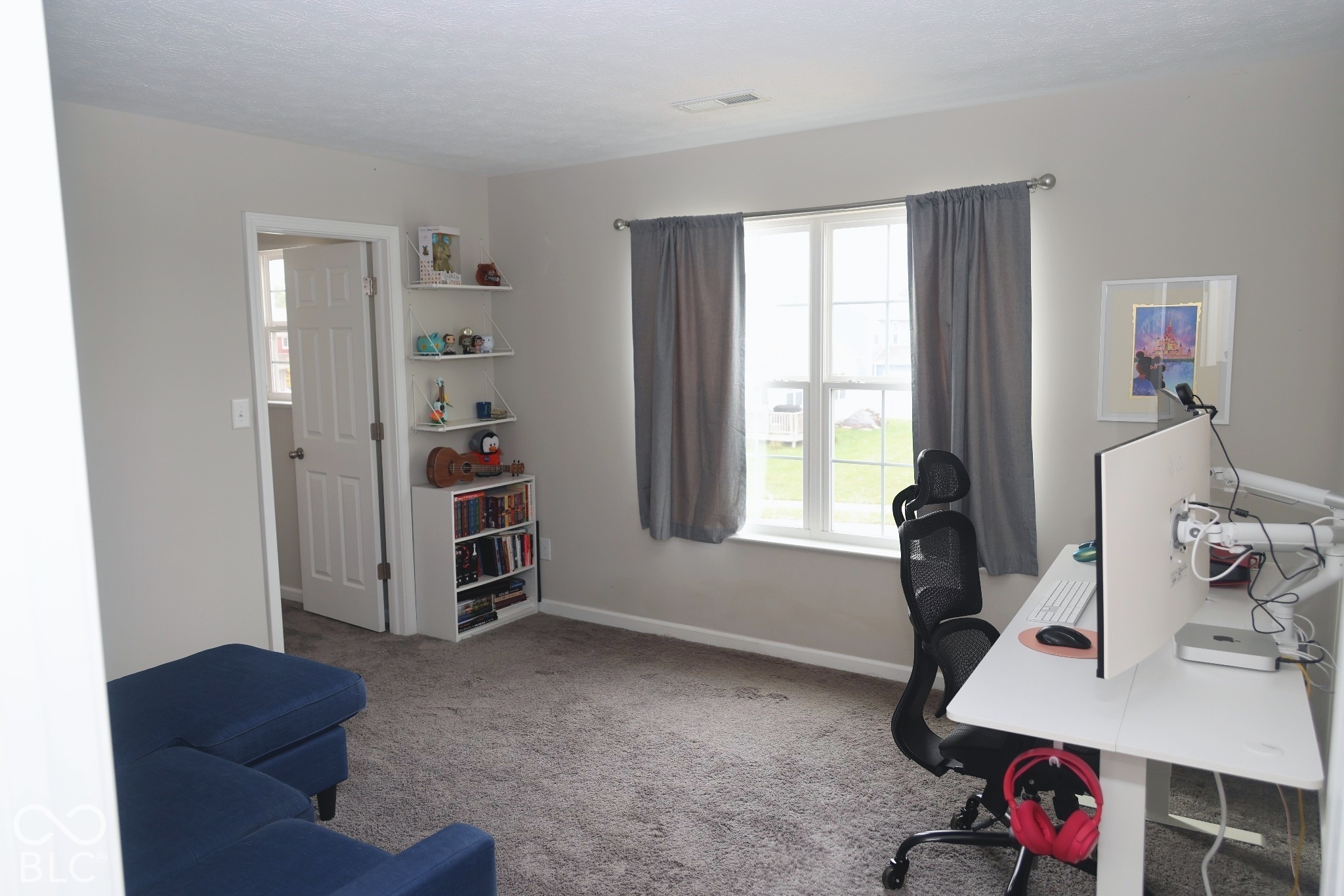 Neutral-toned interior featuring wall-to-wall carpeting, recessed window with muntin detailing, and white multi-panel interior door