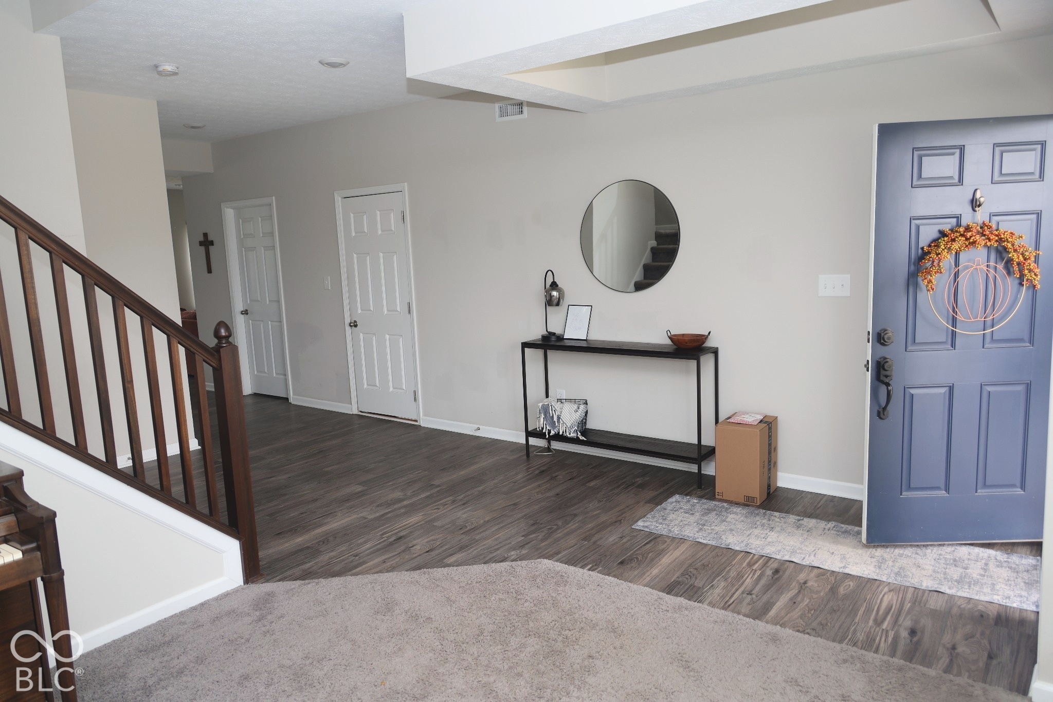 Entryway featuring wood-finish flooring, a paneled front door, recessed lighting, and a staircase with a wooden balustrade
