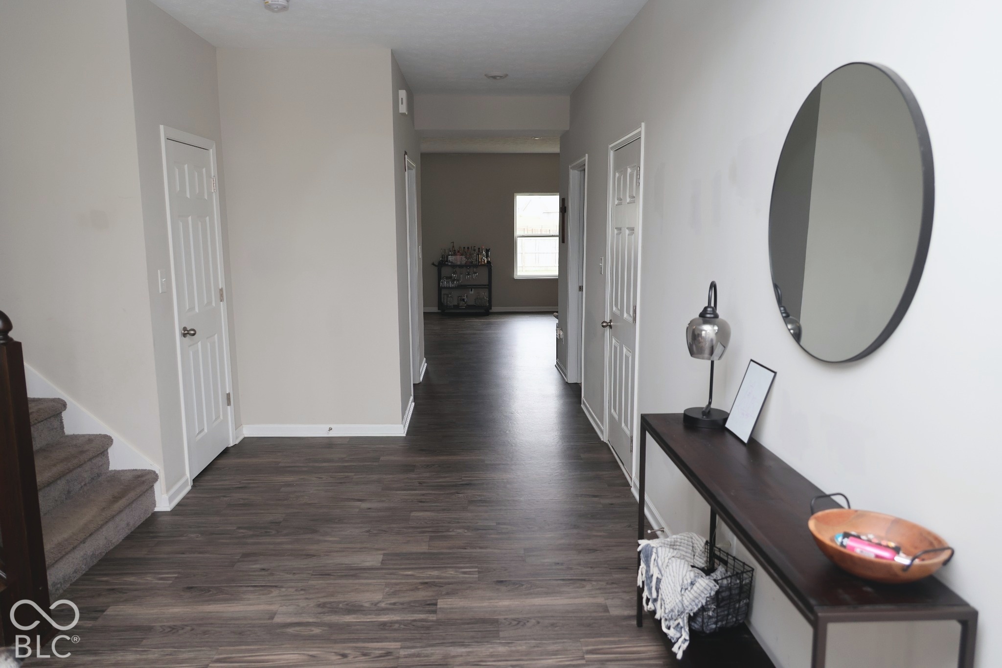 Entryway featuring wood-finish flooring, neutral wall paint, and multiple interior paneled doors
