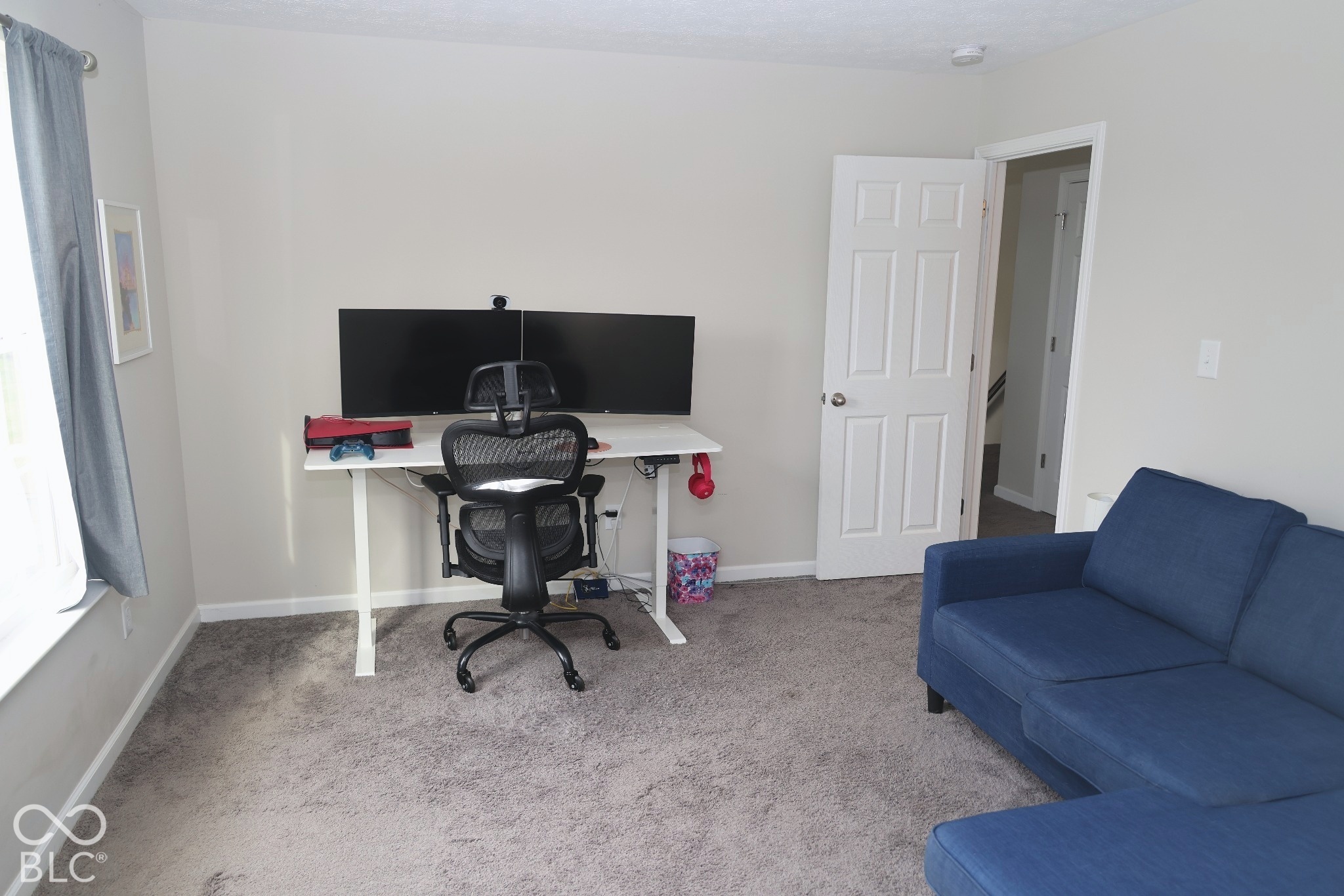 Neutral-toned interior space featuring wall-to-wall carpeting and a traditional six-panel interior door