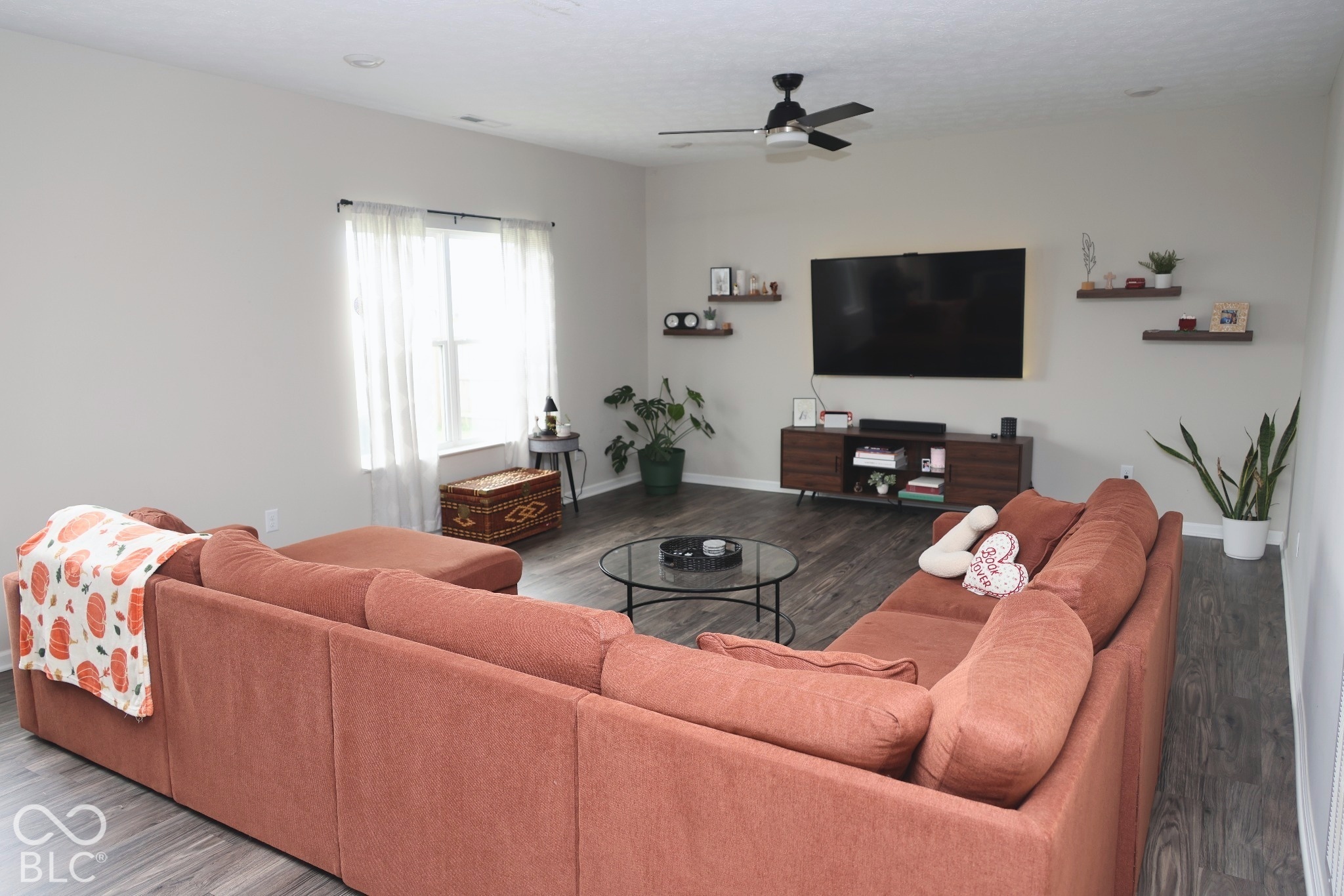 Neutral wall palette featuring wood-finish flooring, recessed lighting, a ceiling fan, and four mounted wall shelves
