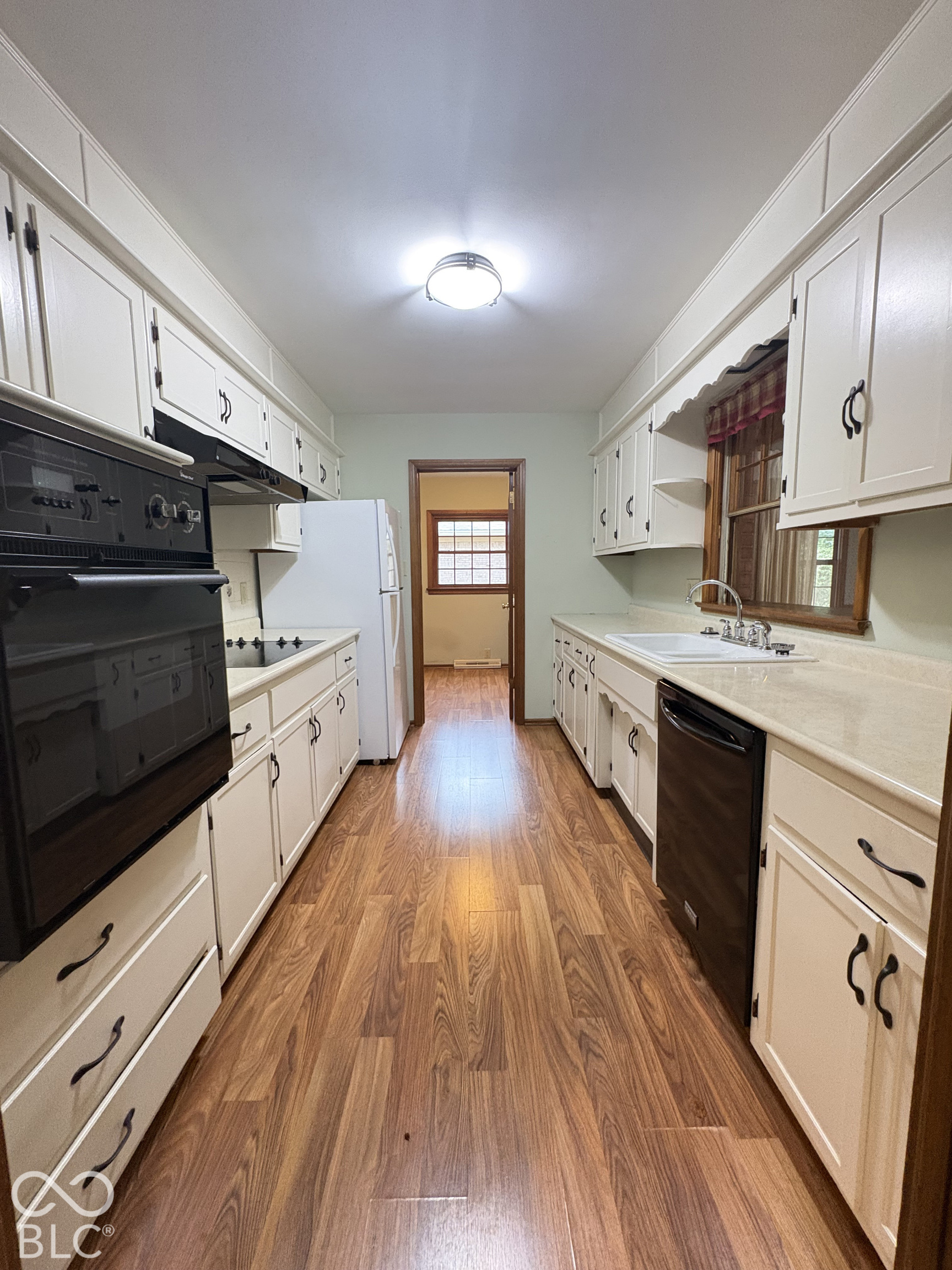 Efficient galley kitchen with pass-through to the rooms in back.