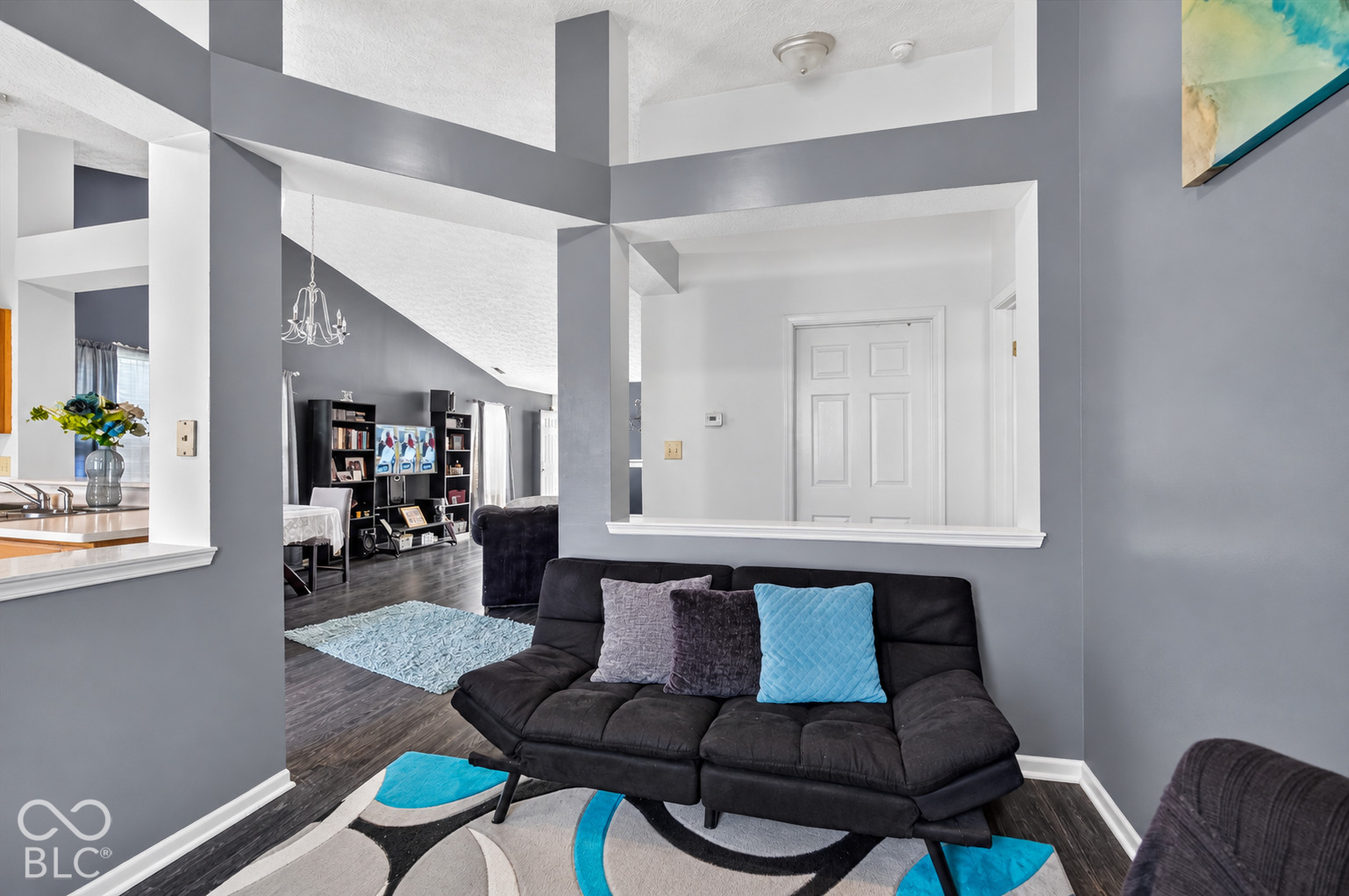 Vaulted ceilings, architectural pass-through wall cutout, and wood-finish flooring