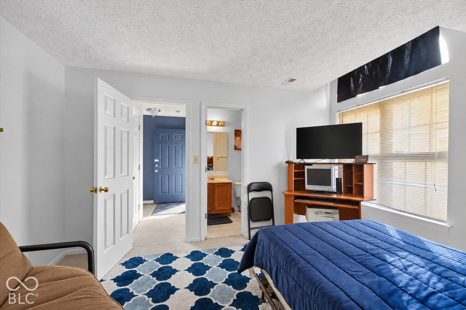 Room featuring neutral wall-to-wall carpeting and a large window with horizontal blinds