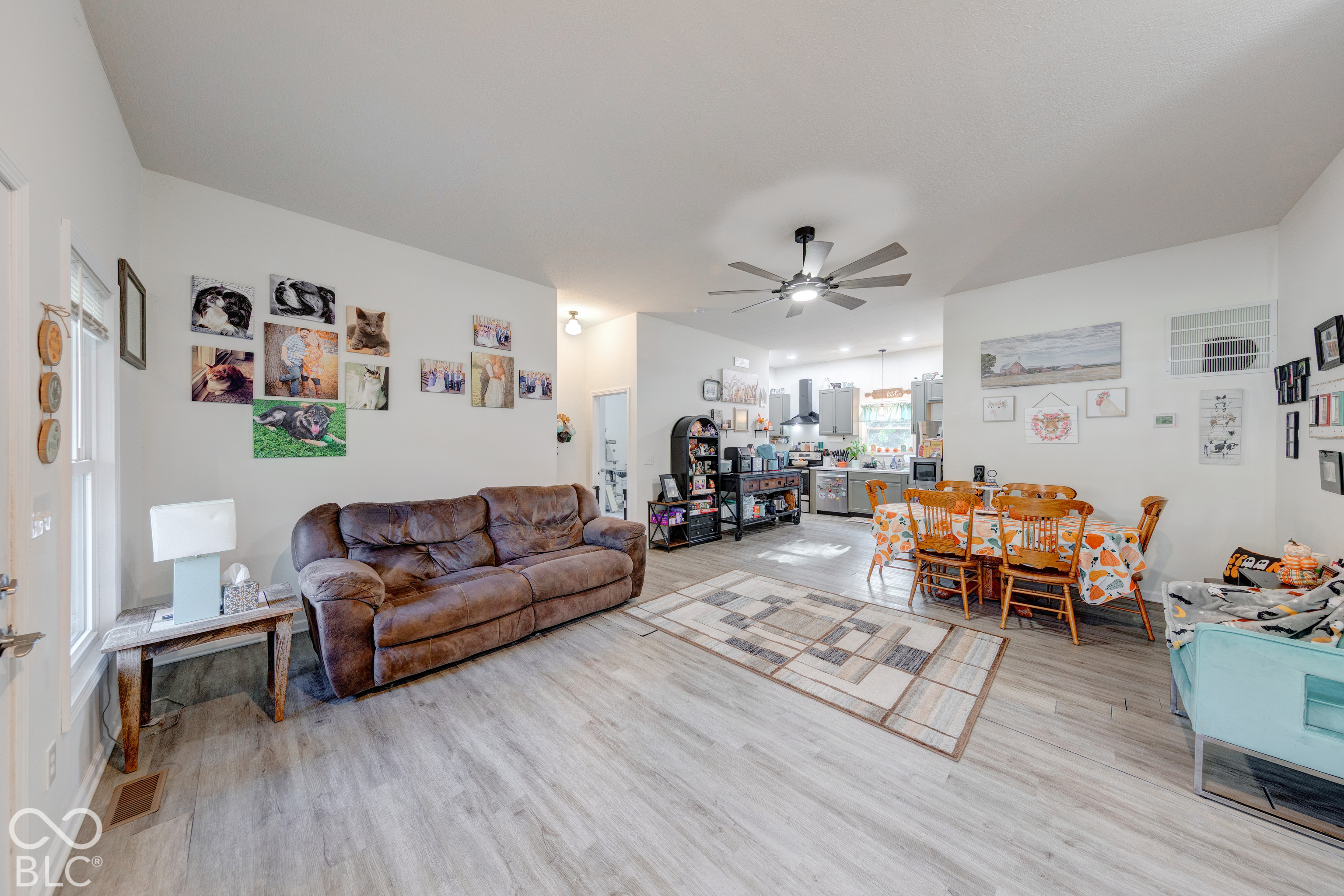 Open concept main living area featuring wood-finish flooring, recessed lighting, and a multi-blade ceiling fan
