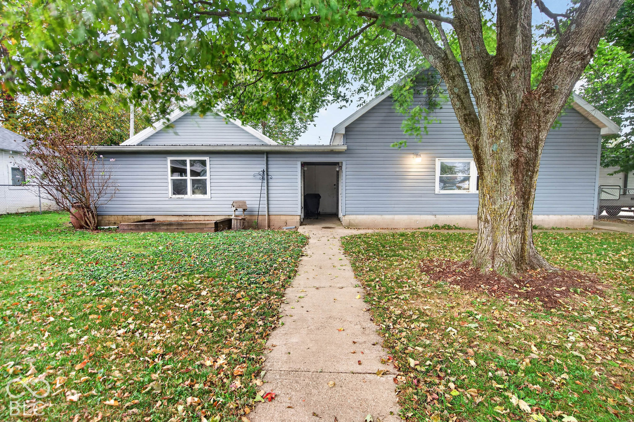 Large detached garage on the right with living quarters or workshop on the left.