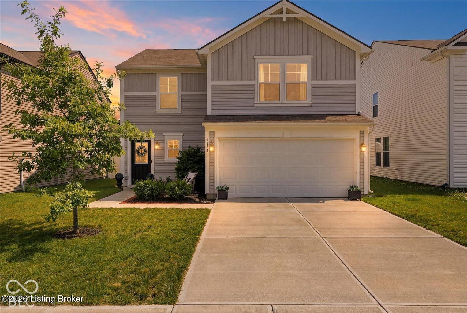 Virtually Altered - Two-story exterior featuring light-toned horizontal siding, a gabled roofline with decorative trim, a two-car garage, and a concrete driveway