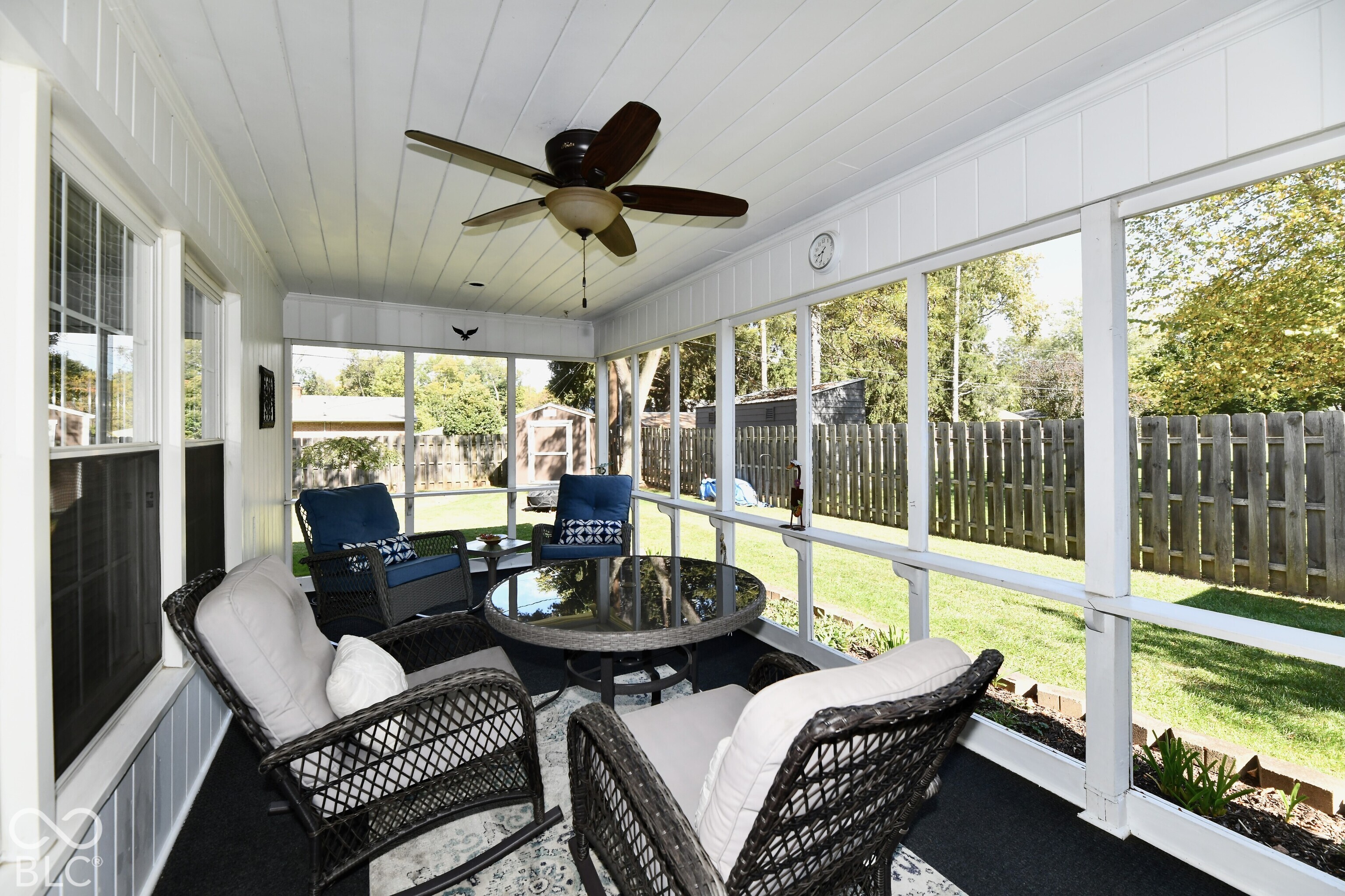 Enclosed porch featuring a tongue-and-groove ceiling, ceiling fan, and full-length screens overlooking a fenced backyard