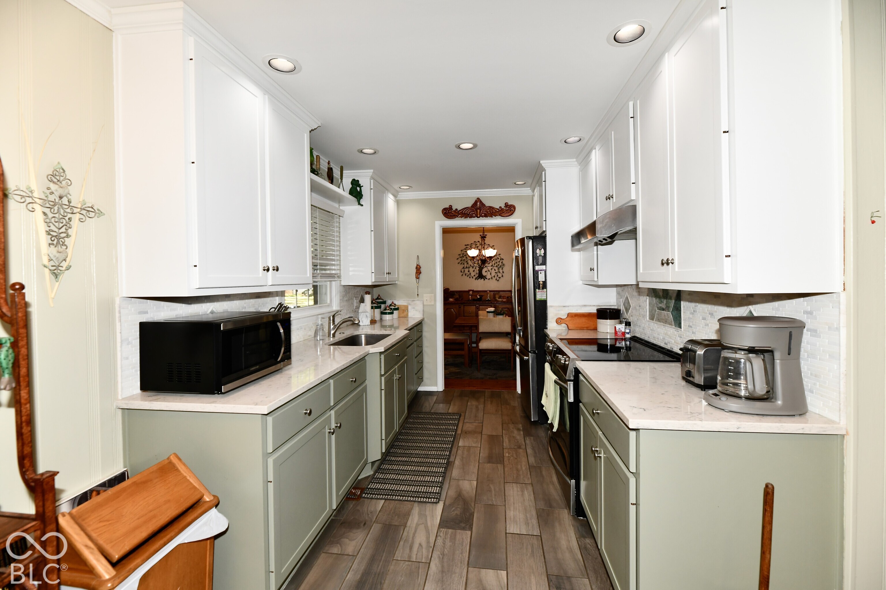 Kitchen featuring two-tone cabinetry, stone-finish countertops, tile backsplash, recessed lighting, and wood-finish flooring
