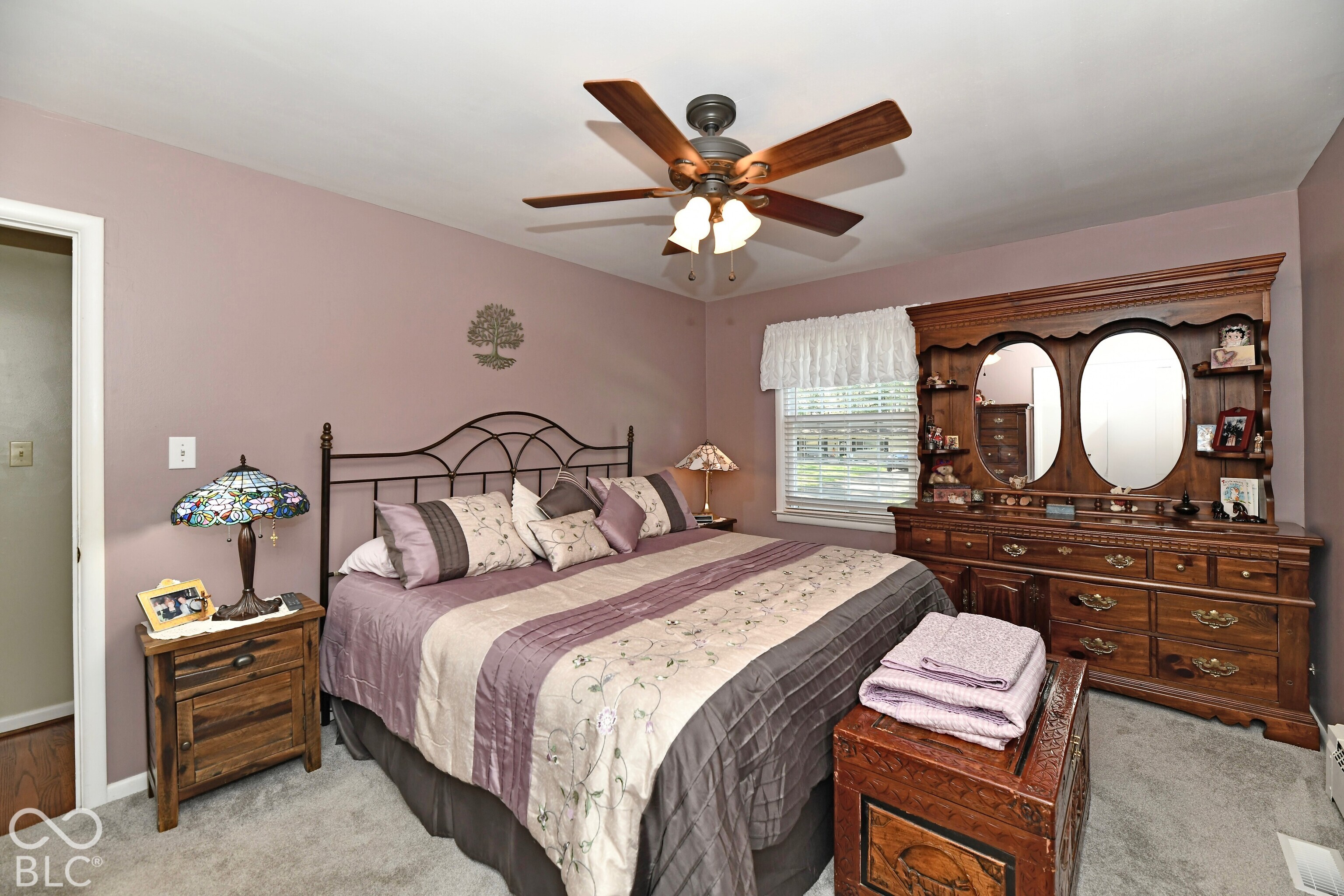 Bedroom featuring wall-to-wall carpeting, a multi-blade ceiling fan with integrated lighting, and a single-pane window with white trim