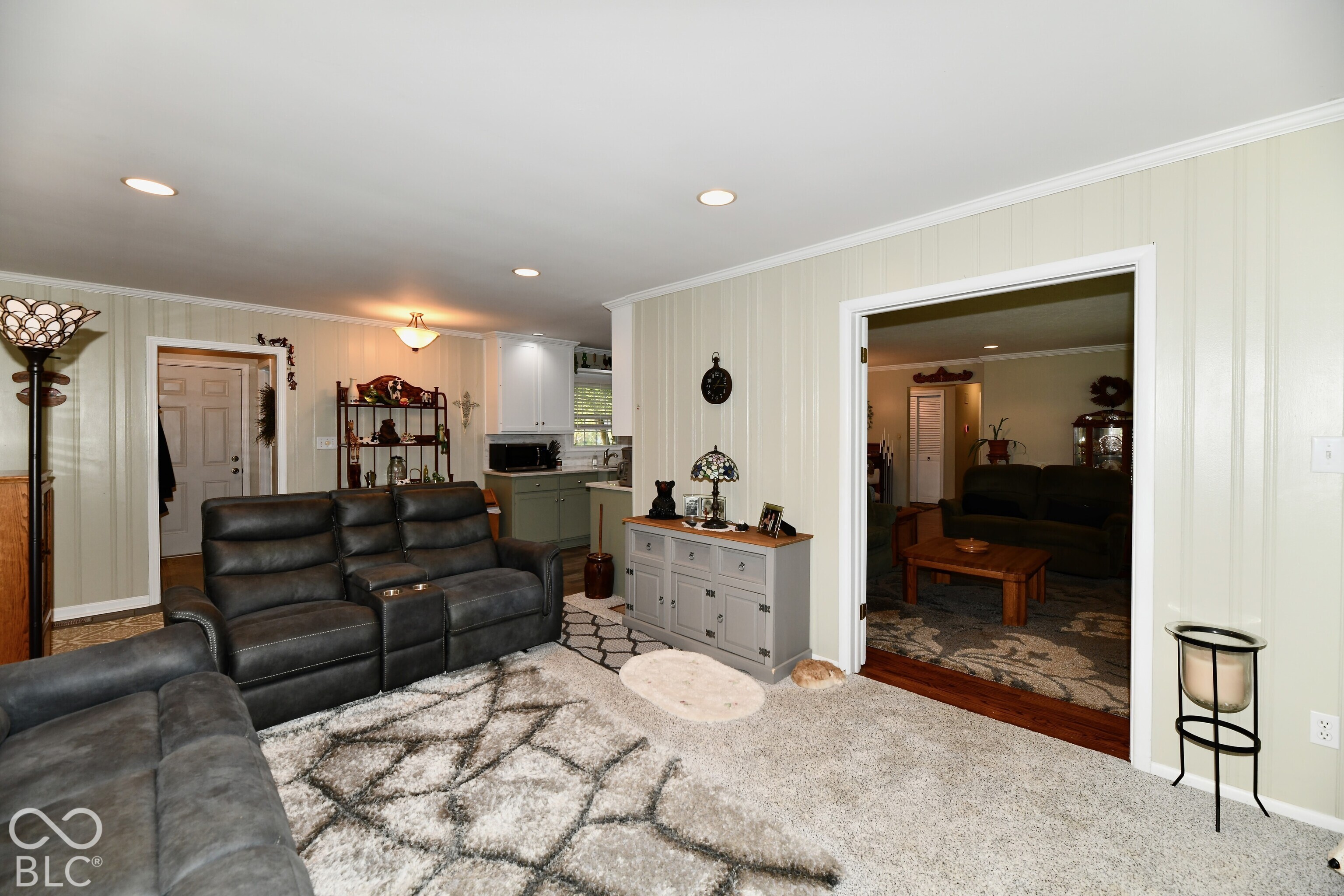 Interior space featuring vertical paneled wall treatments, recessed lighting, and a wide doorway framed by dark wood trim