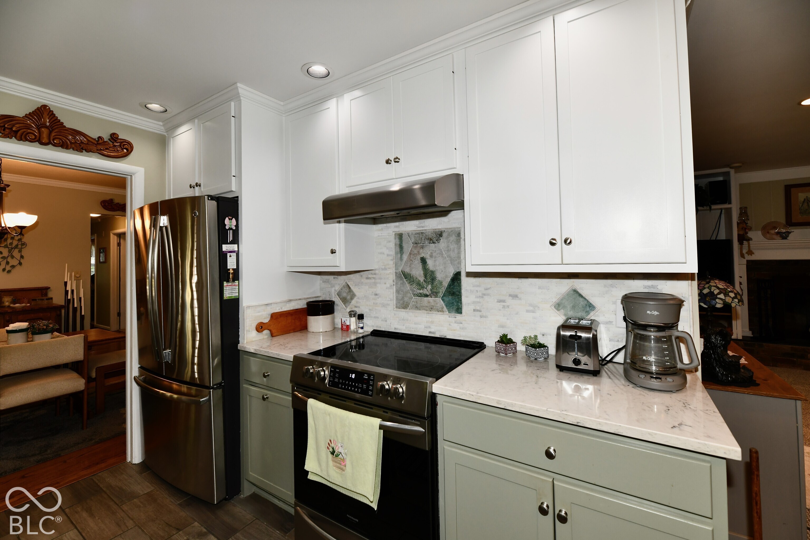 Kitchen featuring two-tone shaker-style cabinetry, stone-finish countertops, stainless steel appliances, recessed ceiling lighting, and a decorative tile backsplash with mosaic accents