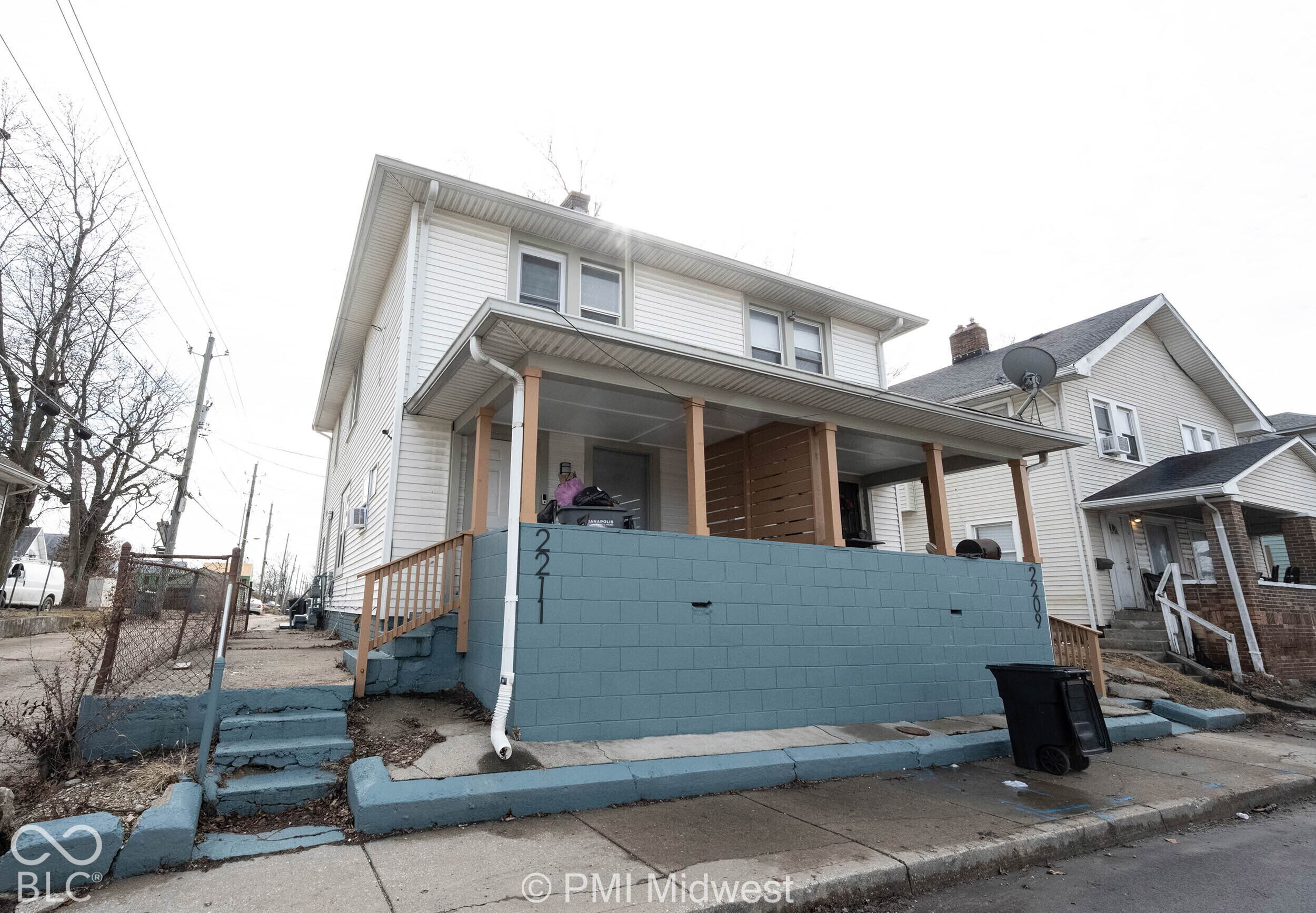 Two-story residence featuring light-colored horizontal siding, a covered front porch, and a raised masonry wall foundation Two-story residence featuring light-colored horizontal siding, a covered front porch, and a raised masonry wall foundation
