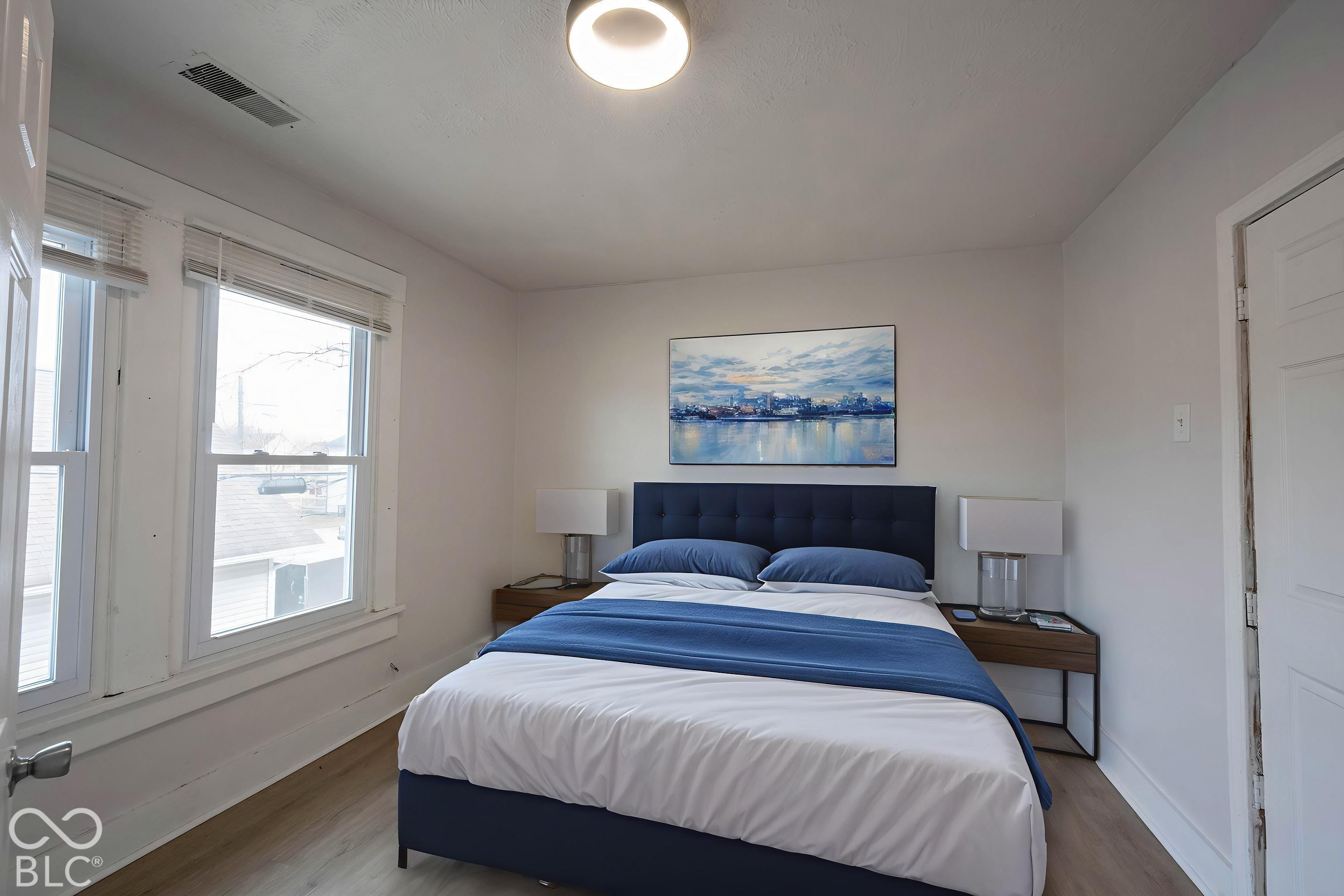 Virtually Altered - Neutral-toned interior featuring wood-finish flooring, dual-pane windows, and a flush-mount overhead light fixture