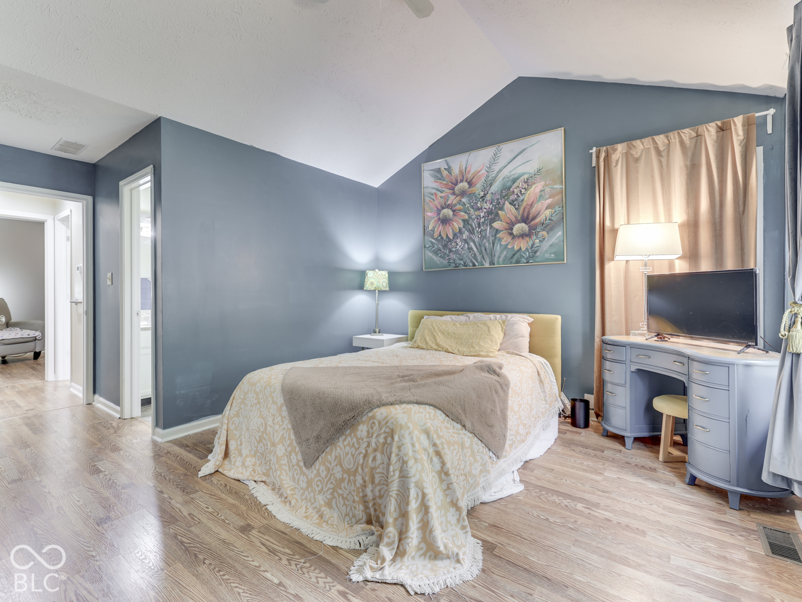 Vaulted ceilings, wood-finish flooring, and neutral wall color