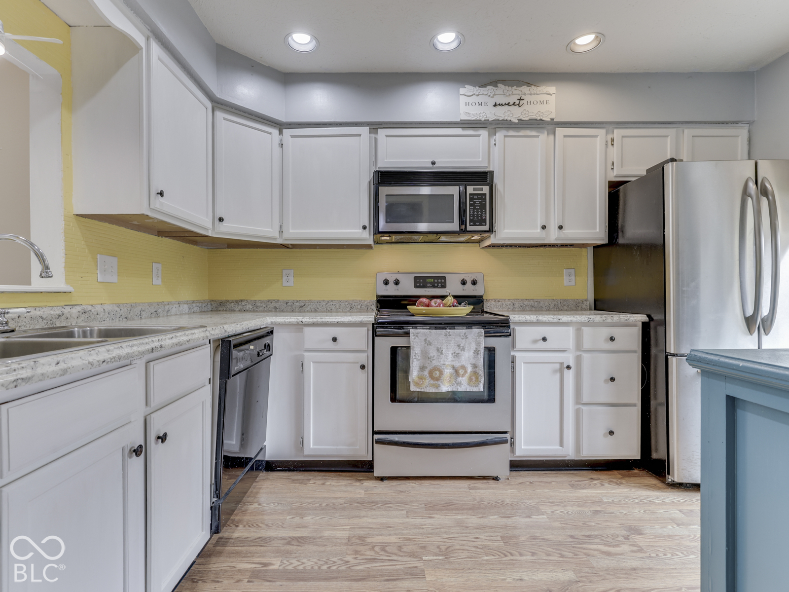 Kitchen featuring white cabinetry, light-toned countertops, stainless steel appliances, and recessed lighting