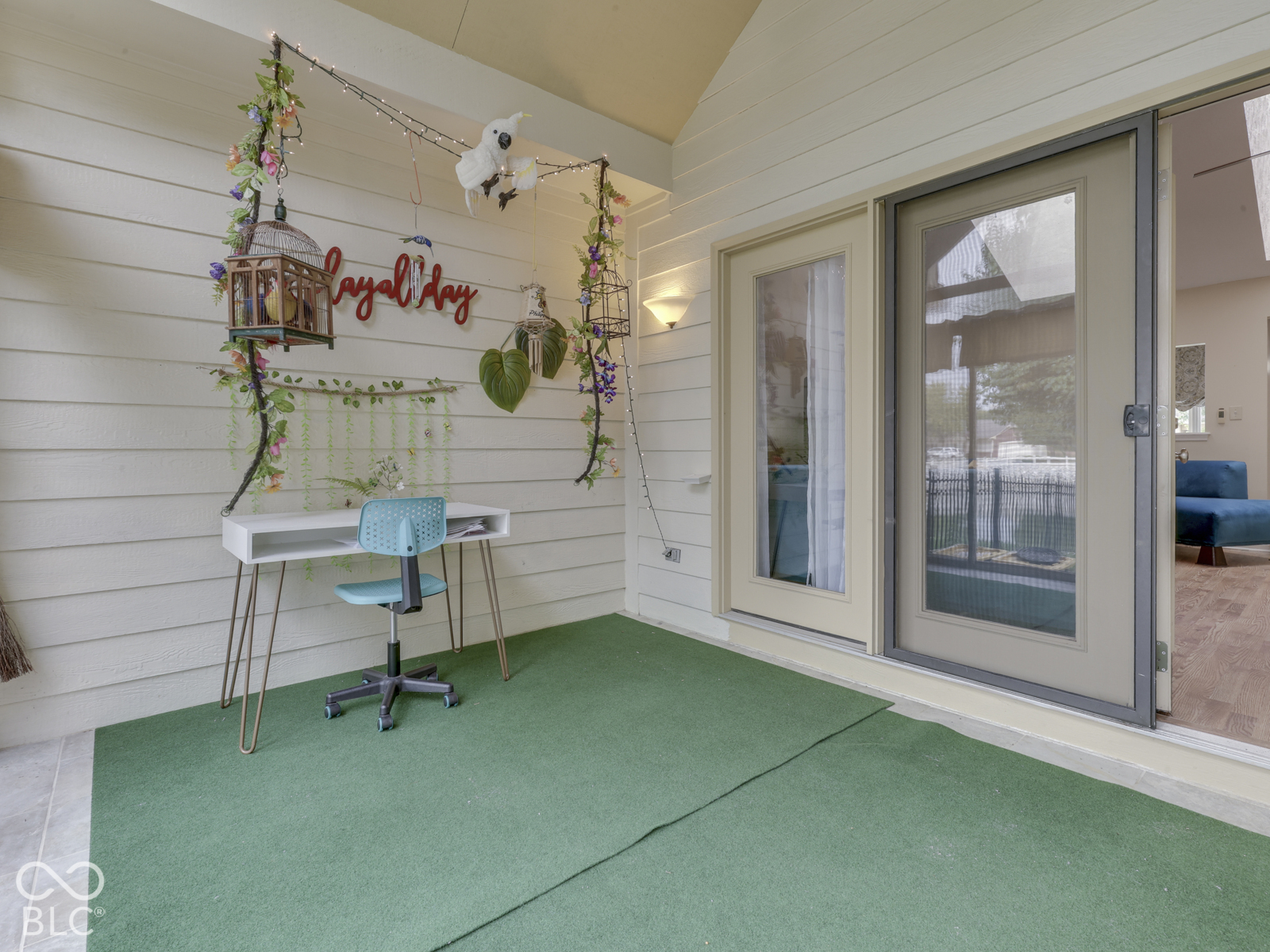 Covered porch featuring horizontal lap siding, wall-mounted light fixture, and a full-glass entry door with screen