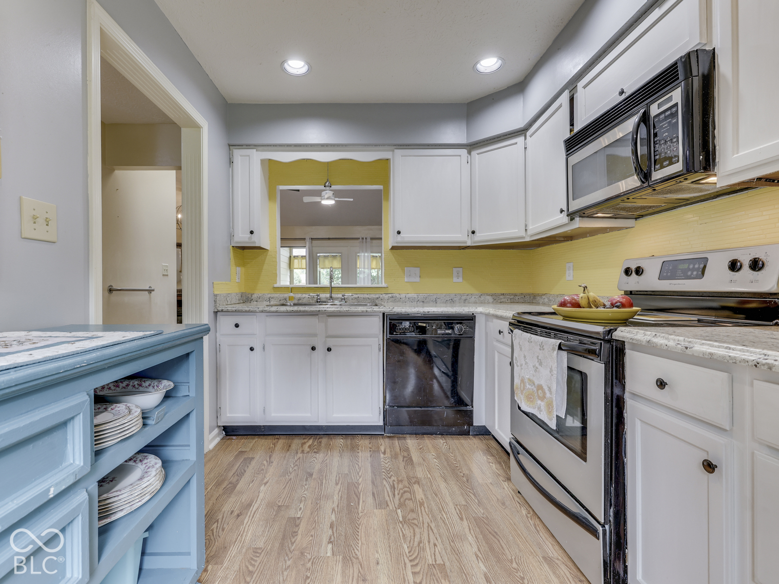 Kitchen featuring white cabinetry, stone-surface countertops, stainless steel appliances, wood-finish flooring, and recessed lighting