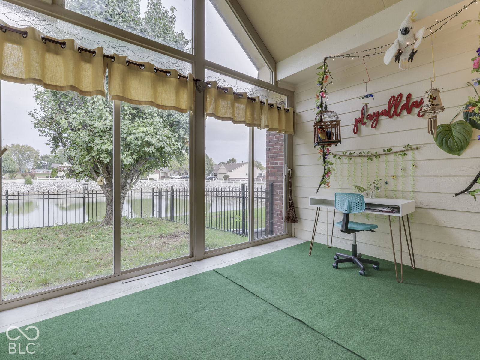 Sunroom featuring floor-to-ceiling windows, vaulted ceilings, and horizontal plank wall paneling
