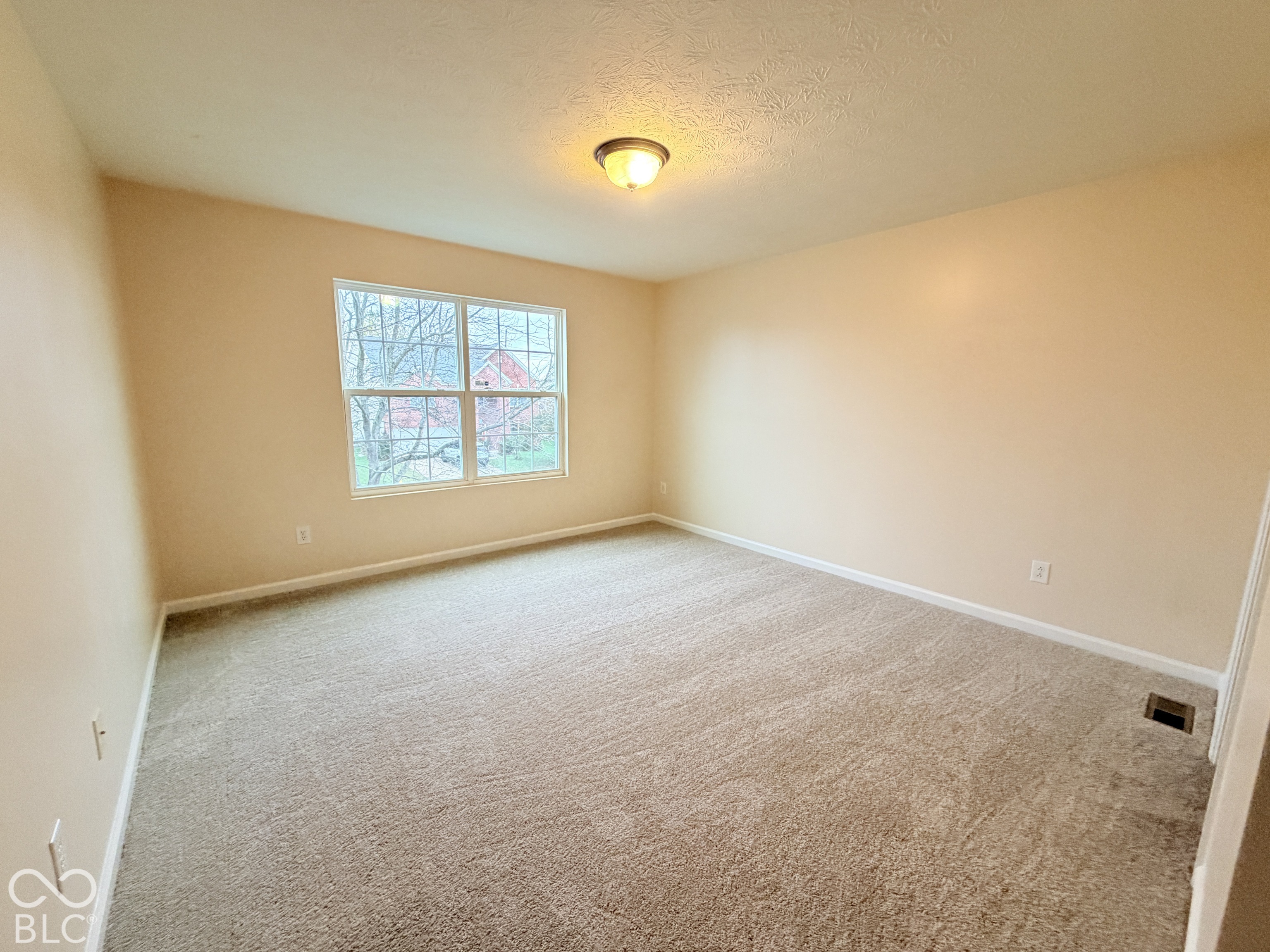 Interior room featuring neutral wall paint, wall-to-wall carpeting, and a double-pane window with a muntin grid