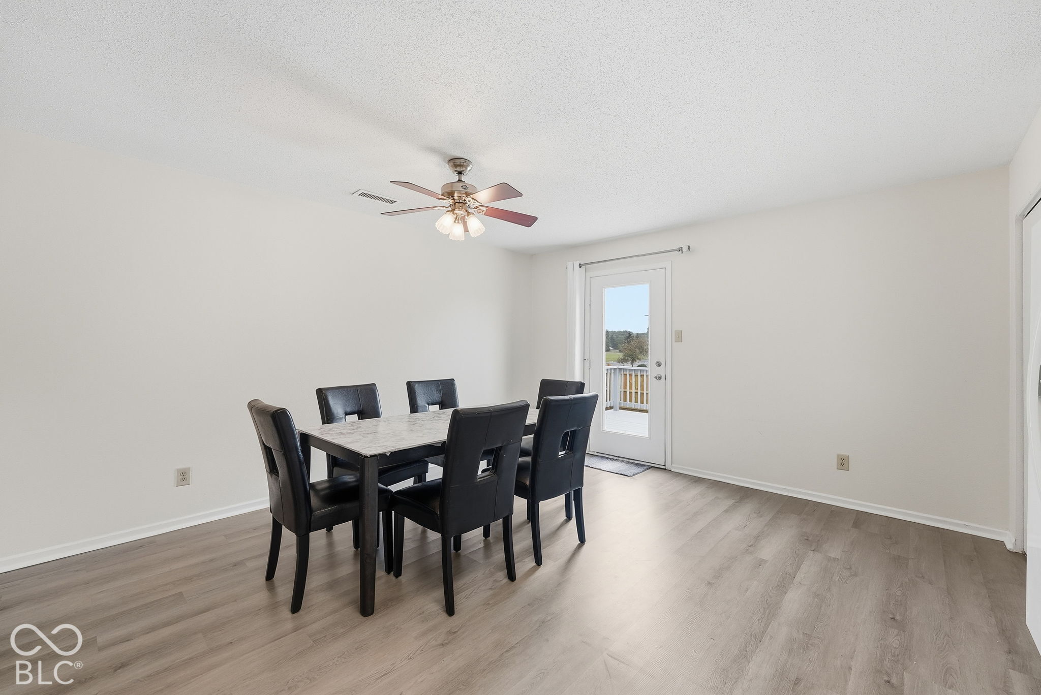 Wood-finish flooring, ceiling fan with integrated lighting, and full-glass exterior door