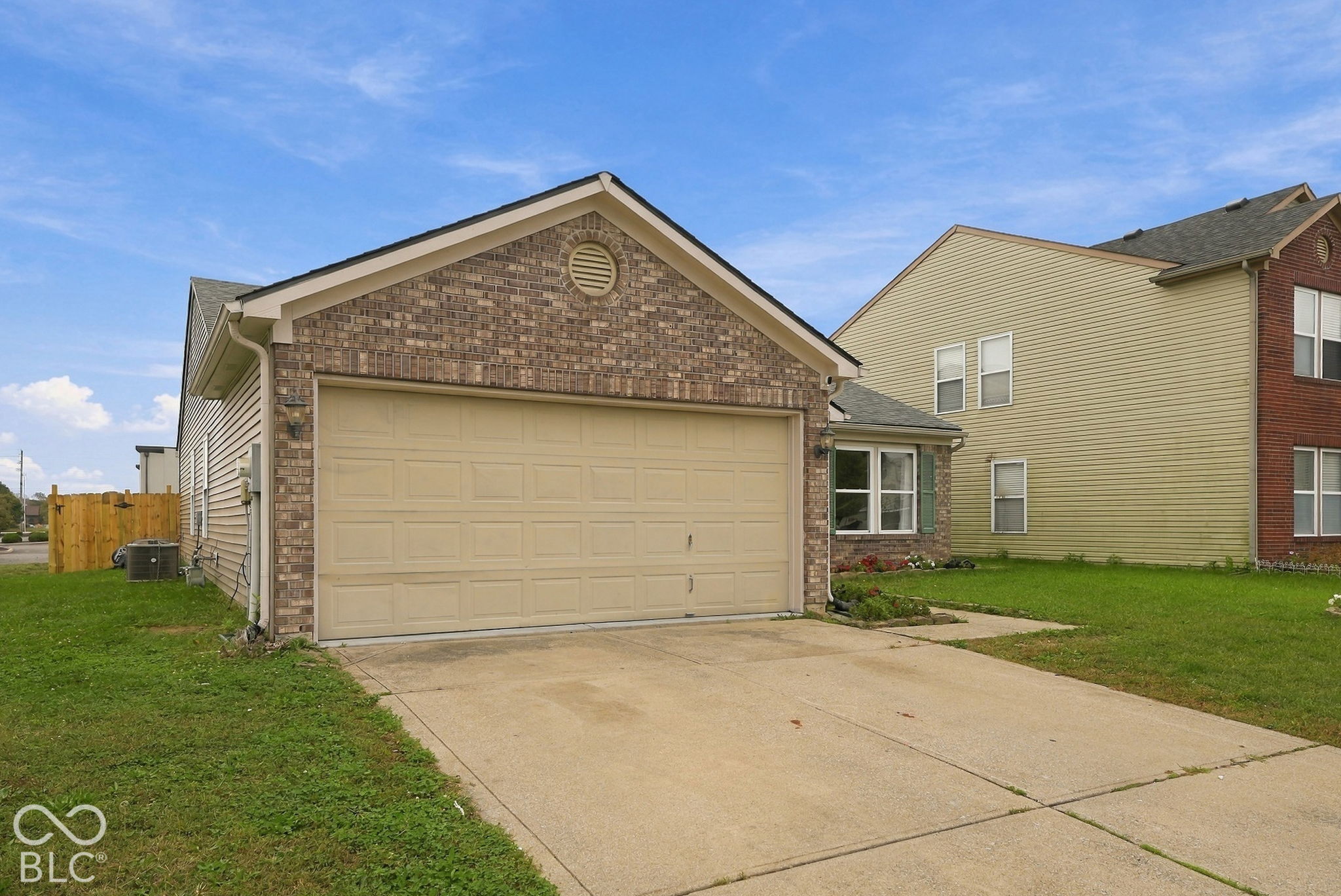 Brick veneer exterior featuring a two-car garage, gable roofline, and concrete driveway Brick veneer exterior featuring a two-car garage, gable roofline, and concrete driveway