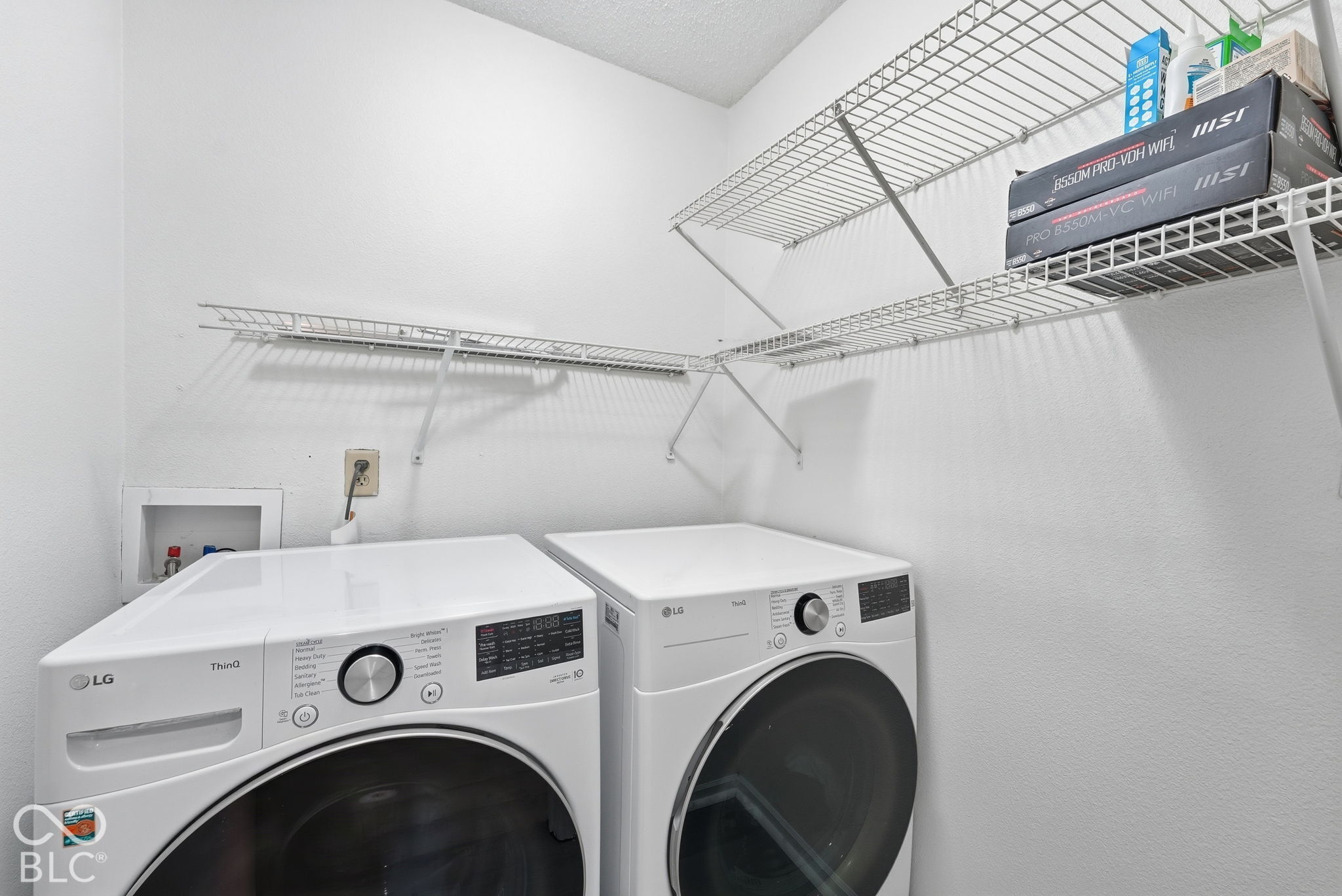 Laundry area featuring dual-tier white wire shelving and recessed washer and dryer utility connections