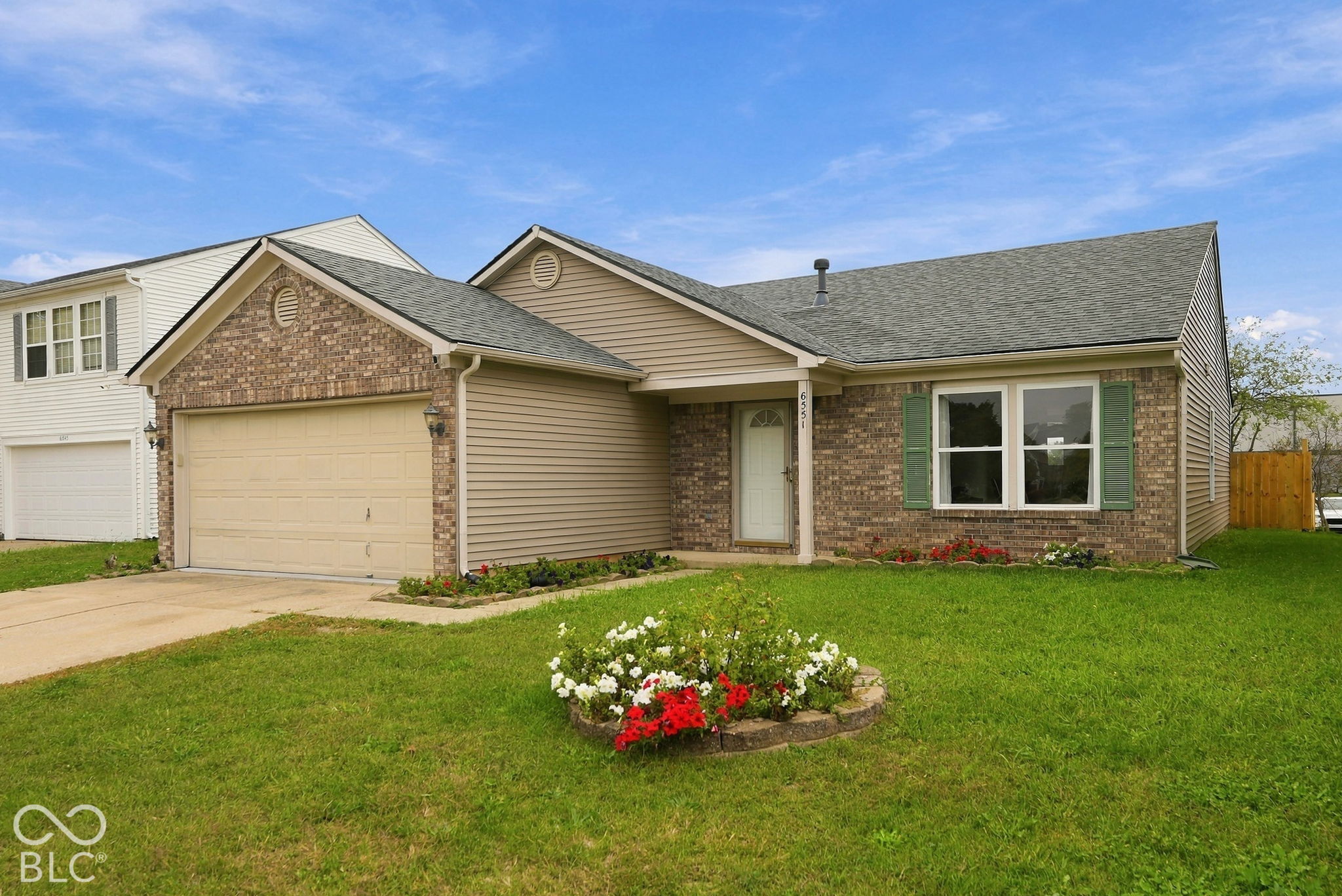 Exterior facade featuring brick masonry and horizontal siding, a gabled roofline, an attached two-car garage, and decorative window shutters Exterior facade featuring brick masonry and horizontal siding, a gabled roofline, an attached two-car garage, and decorative window shutters