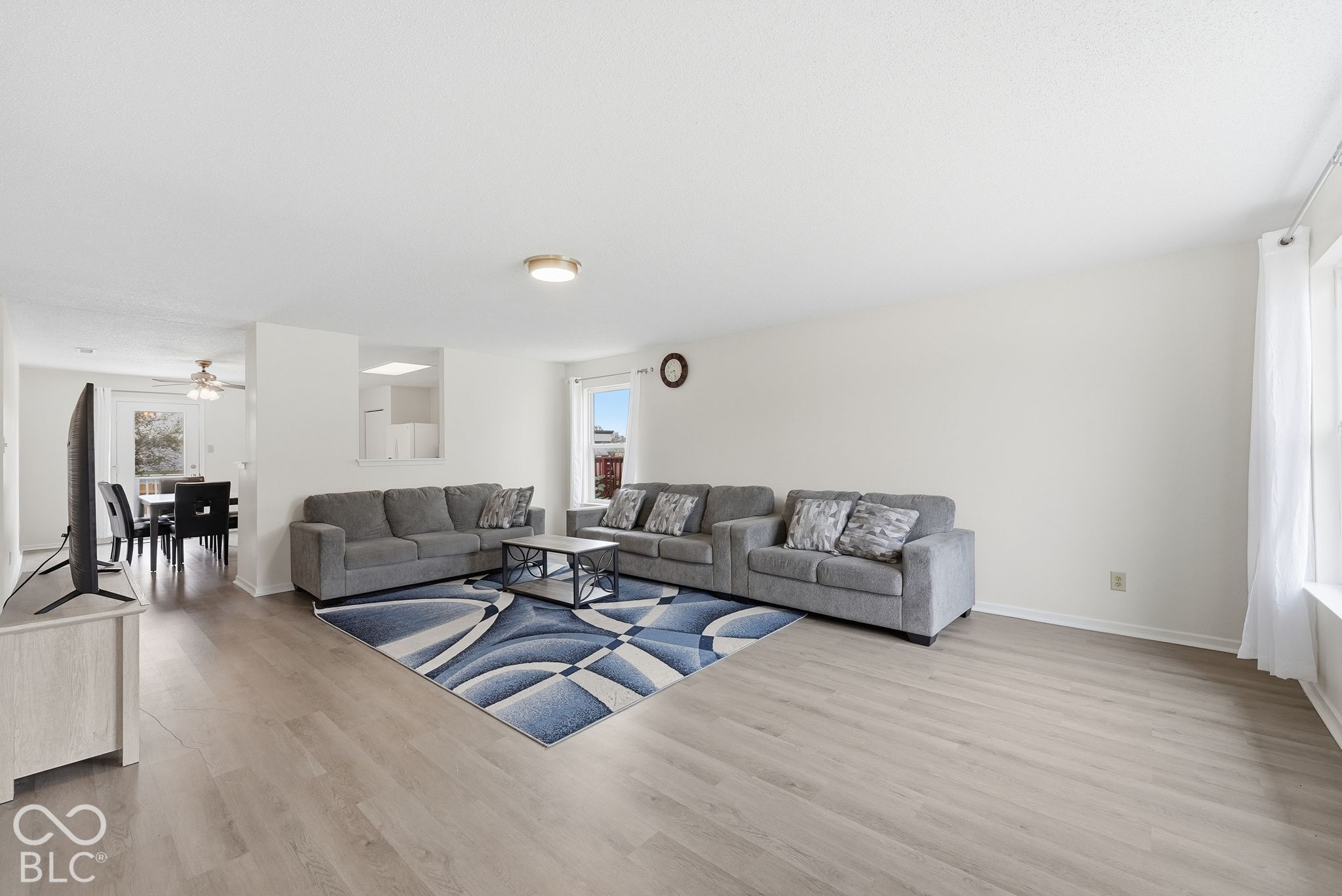 Neutral-toned interior space featuring light wood-finish flooring, crisp white walls, and a recessed pass-through opening Neutral-toned interior space featuring light wood-finish flooring, crisp white walls, and a recessed pass-through opening