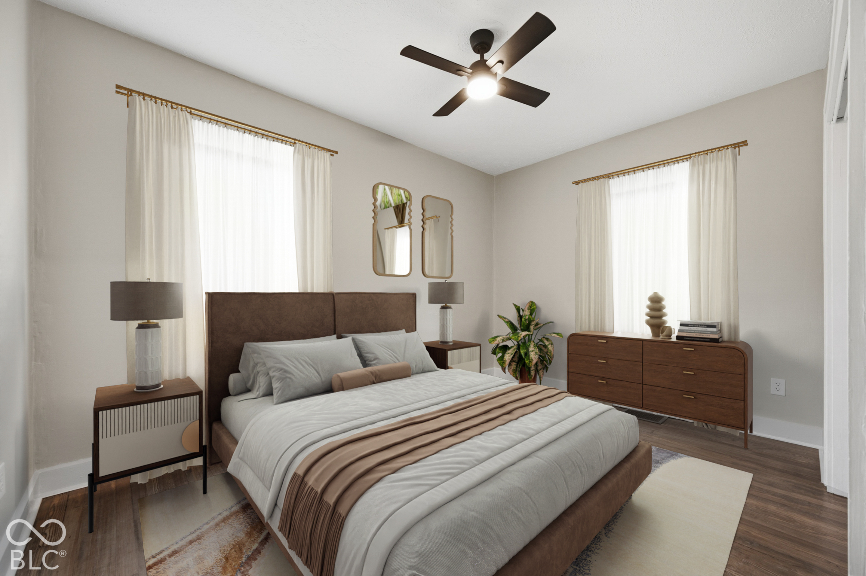 Neutral-toned interior featuring wood-finish flooring, dual windows with mounted drapery hardware, and a ceiling-mounted light fixture with an integrated fan