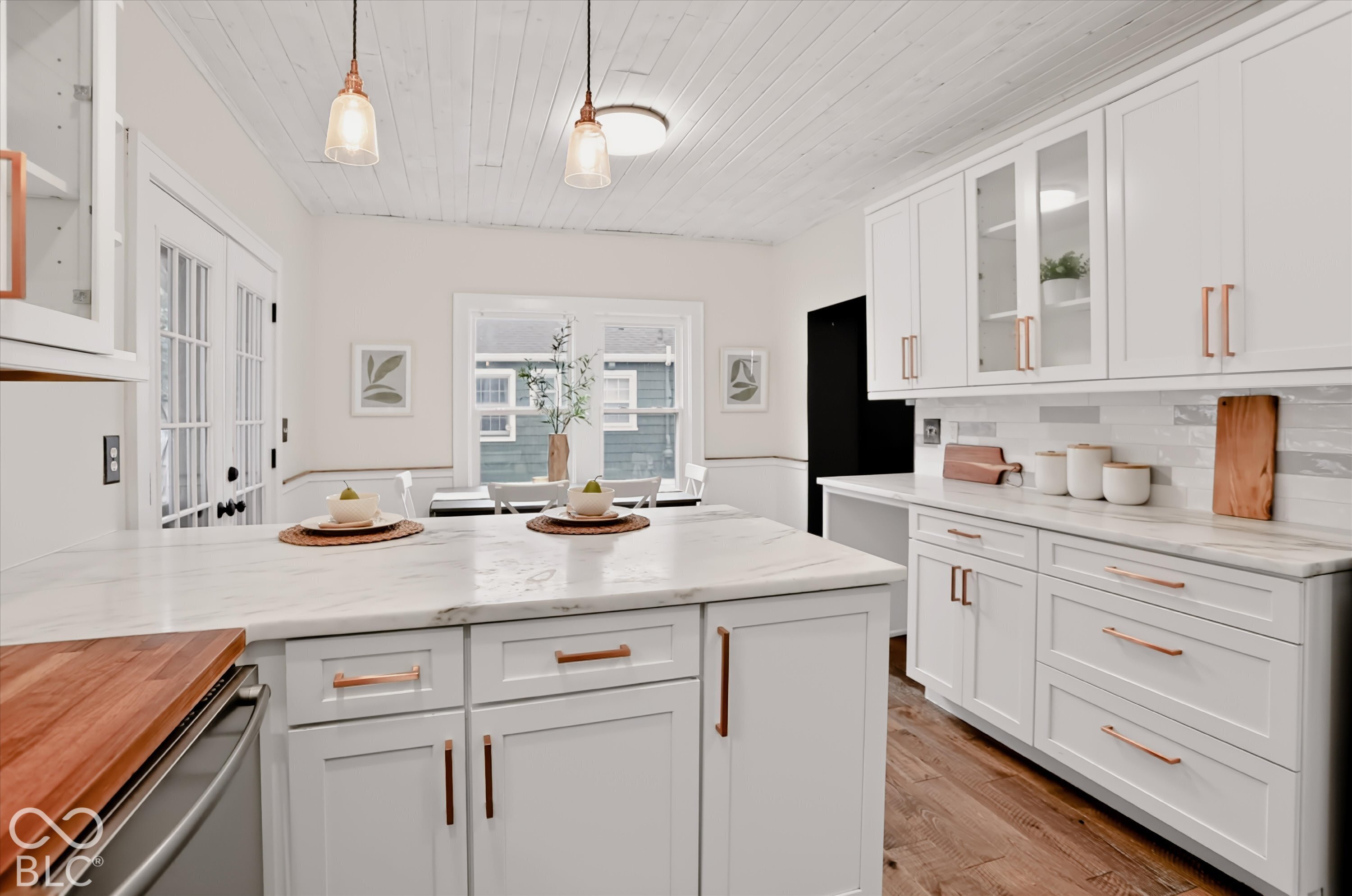 Kitchen featuring white shaker cabinetry, stone-surface countertops, wood-finish flooring, plank-style ceiling, and copper-toned hardware