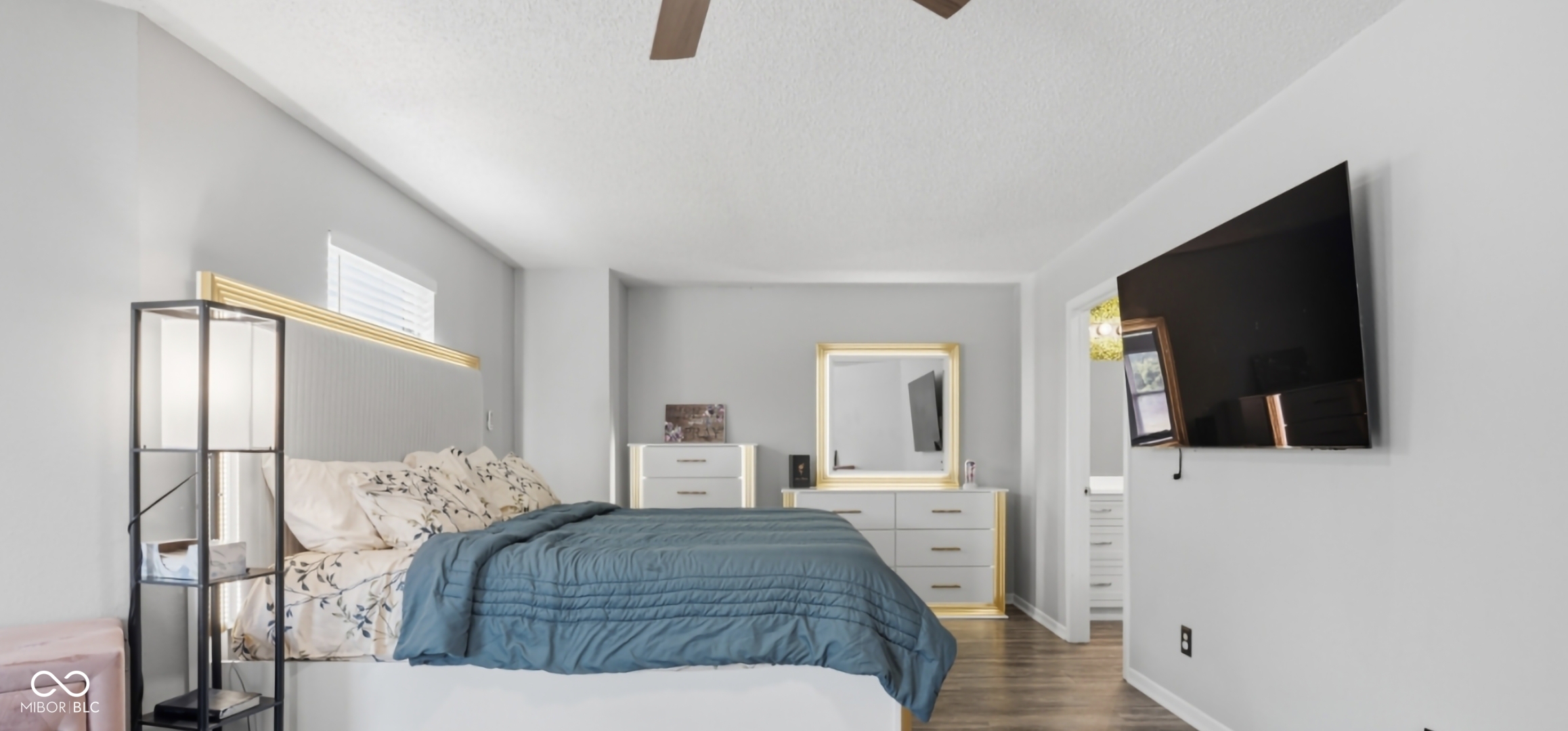 Bedroom featuring wood-finish flooring, a ceiling fan, and a wall-mounted television