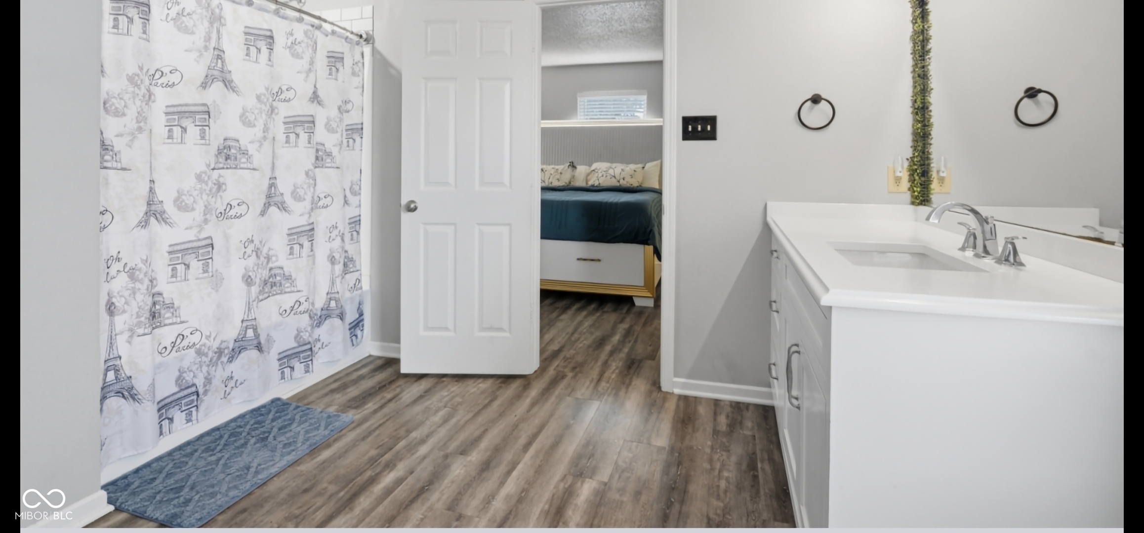 Bathroom featuring wood-finish flooring and a single vanity with a white countertop