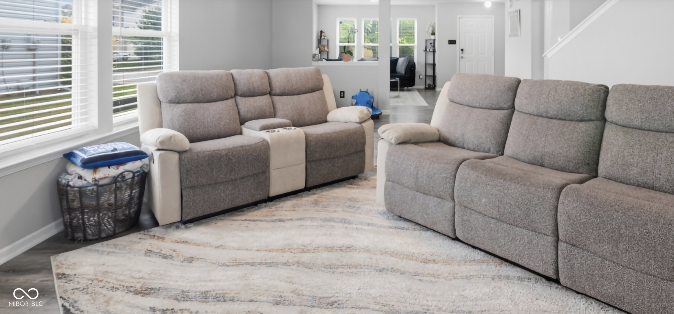 Open-concept living area featuring light gray wall paint, white trim, and wood-finish flooring