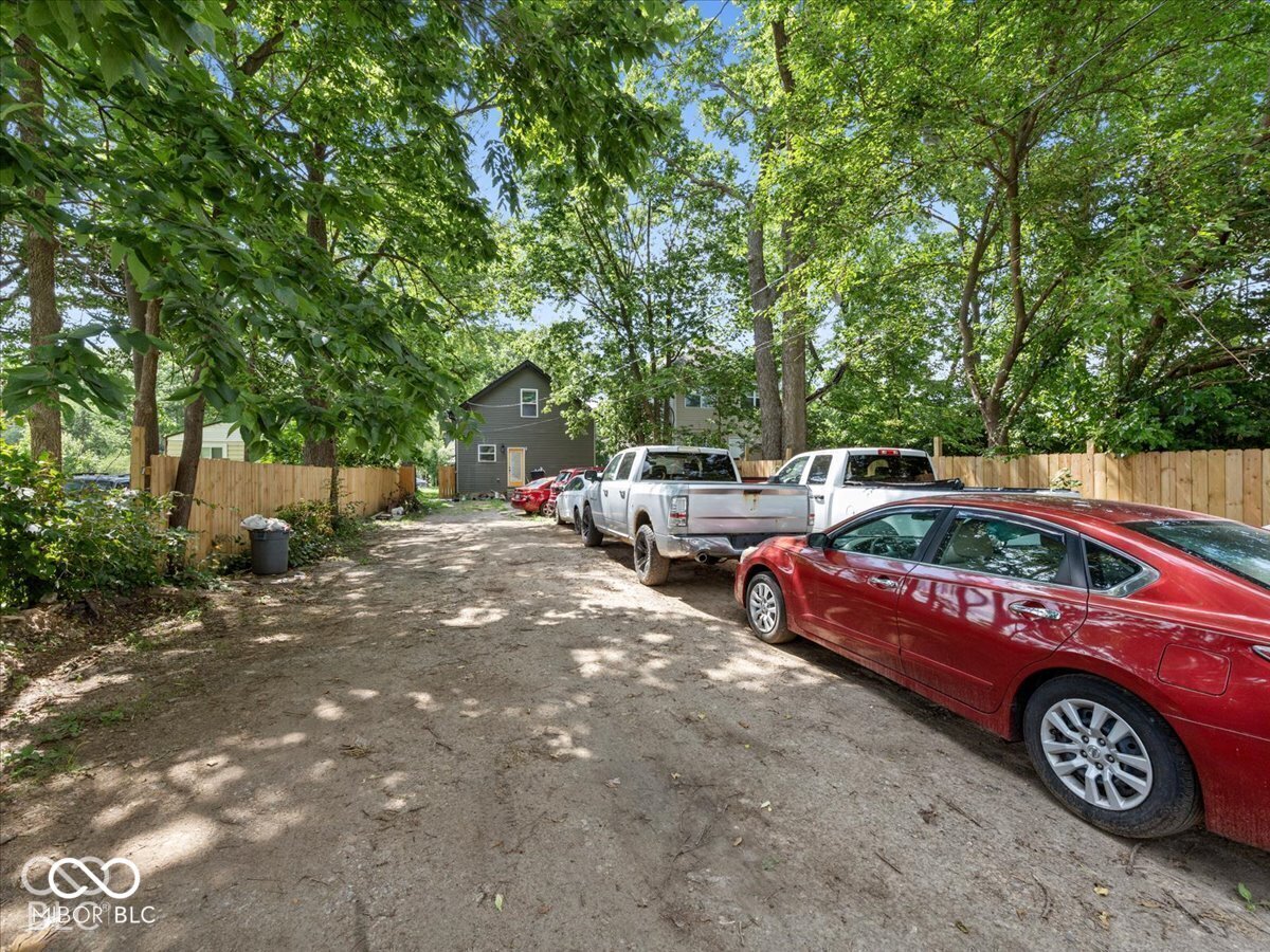 Unpaved surface with wood privacy fencing and mature trees