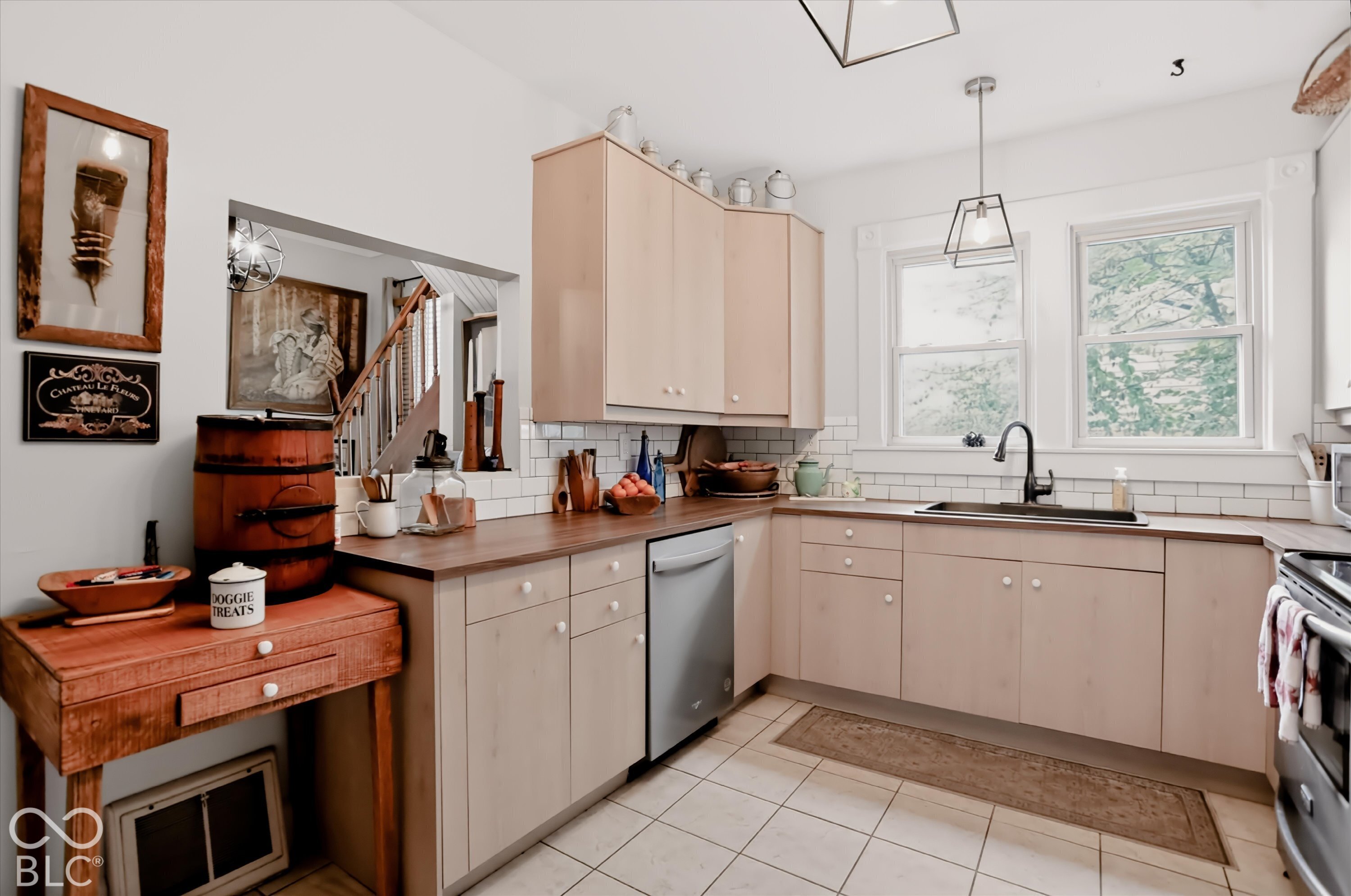 Kitchen featuring light-finish cabinetry, dark wood-tone countertops, white subway tile backsplash, ceramic tile flooring, and matte black hardware