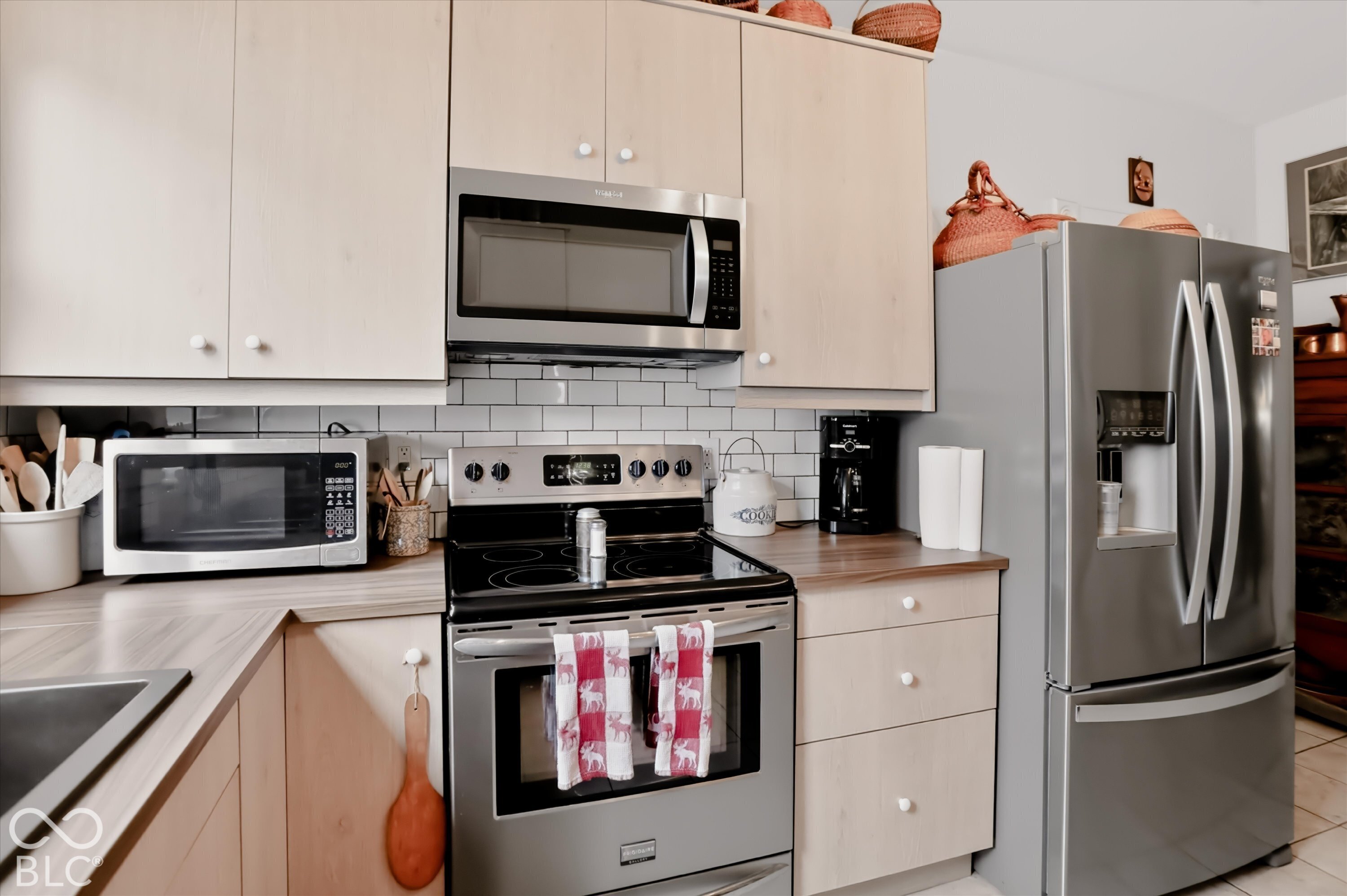 Kitchen featuring light-finish cabinetry, stainless steel appliances, a glass-top electric range, and a subway tile backsplash