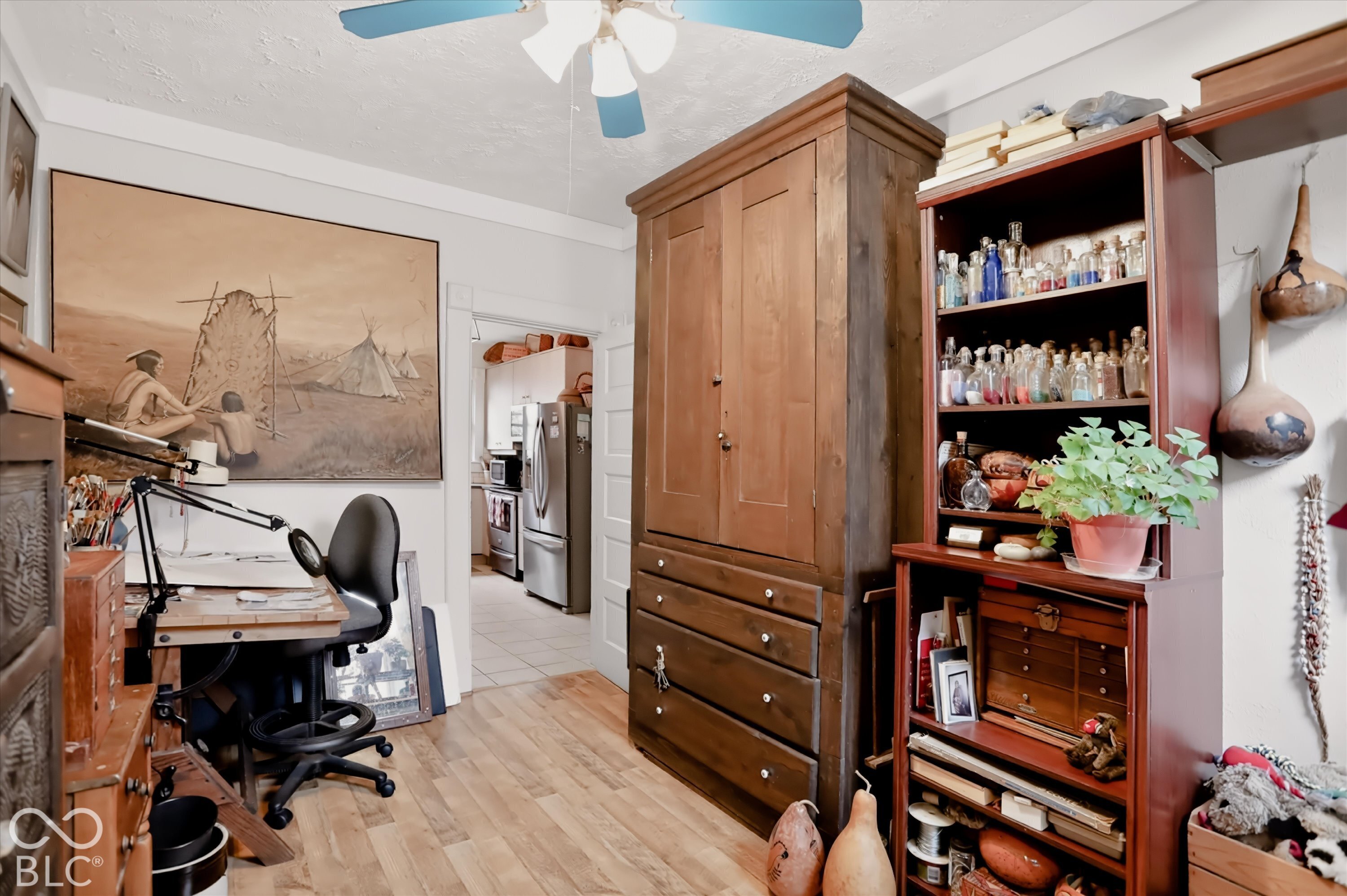 Room featuring wood-finish flooring and a ceiling-mounted fan with light fixture