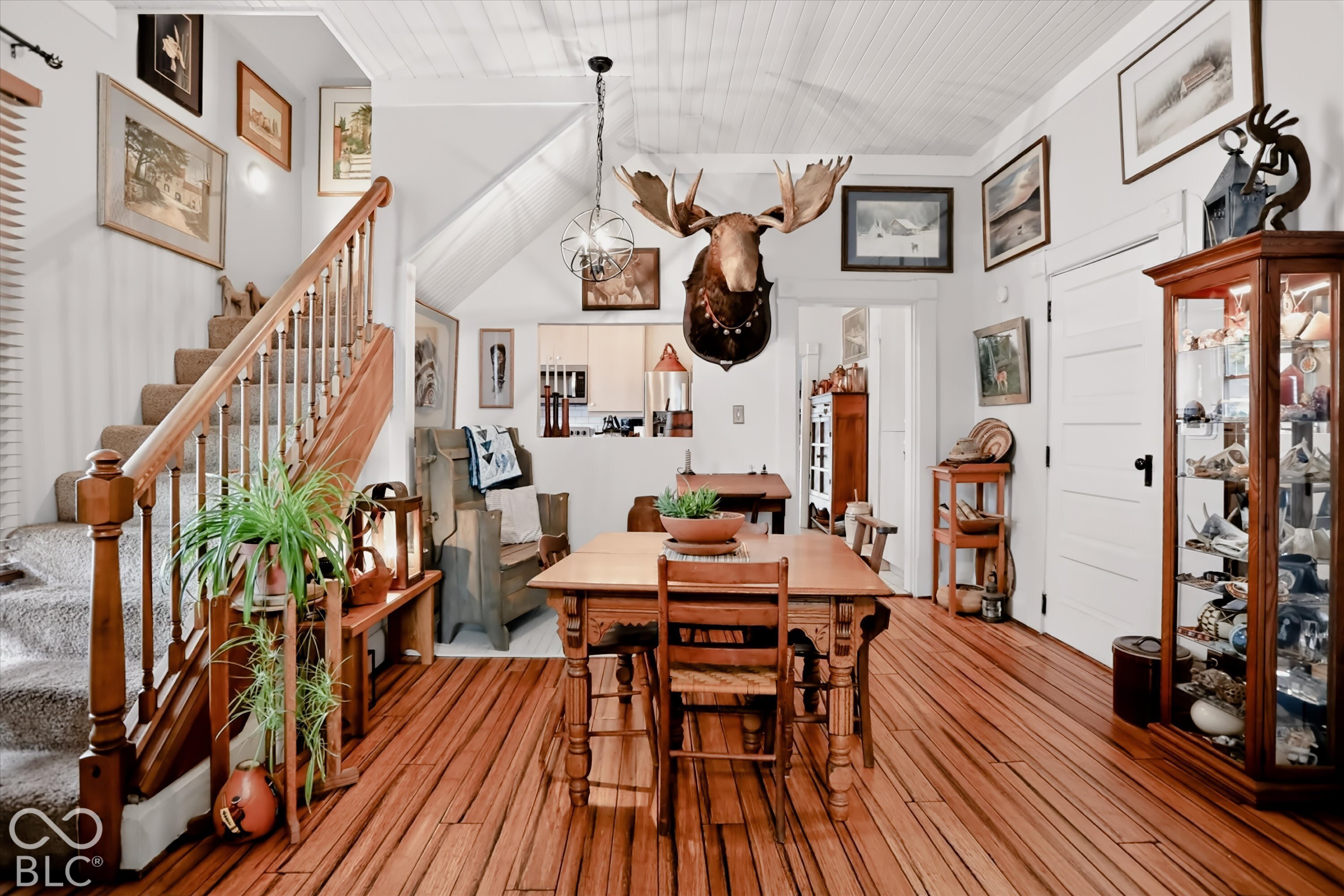Interior space featuring wood-finish flooring, vaulted shiplap ceiling, staircase with wooden balusters, and a spherical metal chandelier