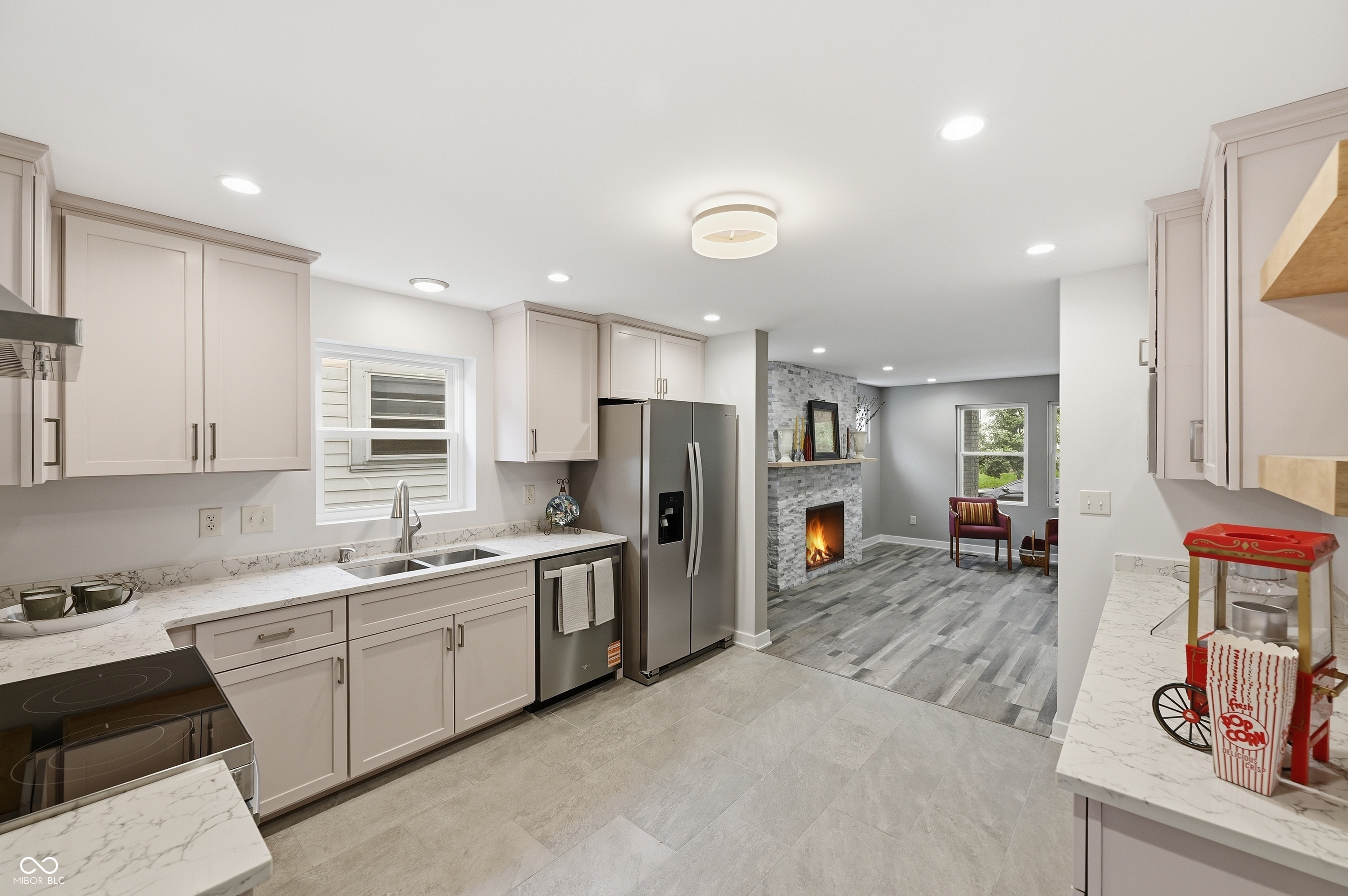 Contemporary kitchen featuring light cabinetry, quartz countertops, stainless steel appliances, and tile flooring
