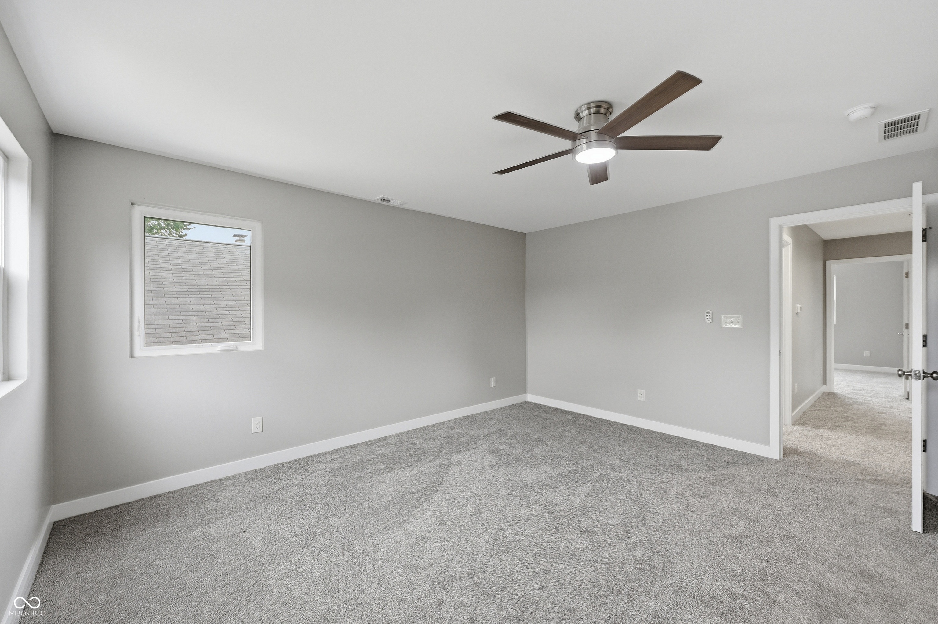 Spacious room with plush gray carpeting and neutral wall tones