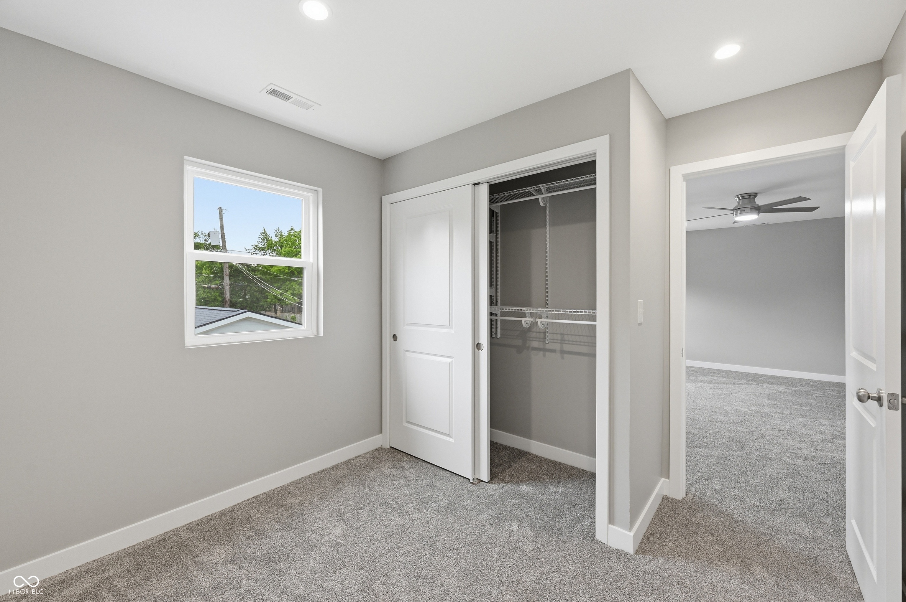 Interior room featuring plush gray carpeting, light gray wall paint, and white trim
