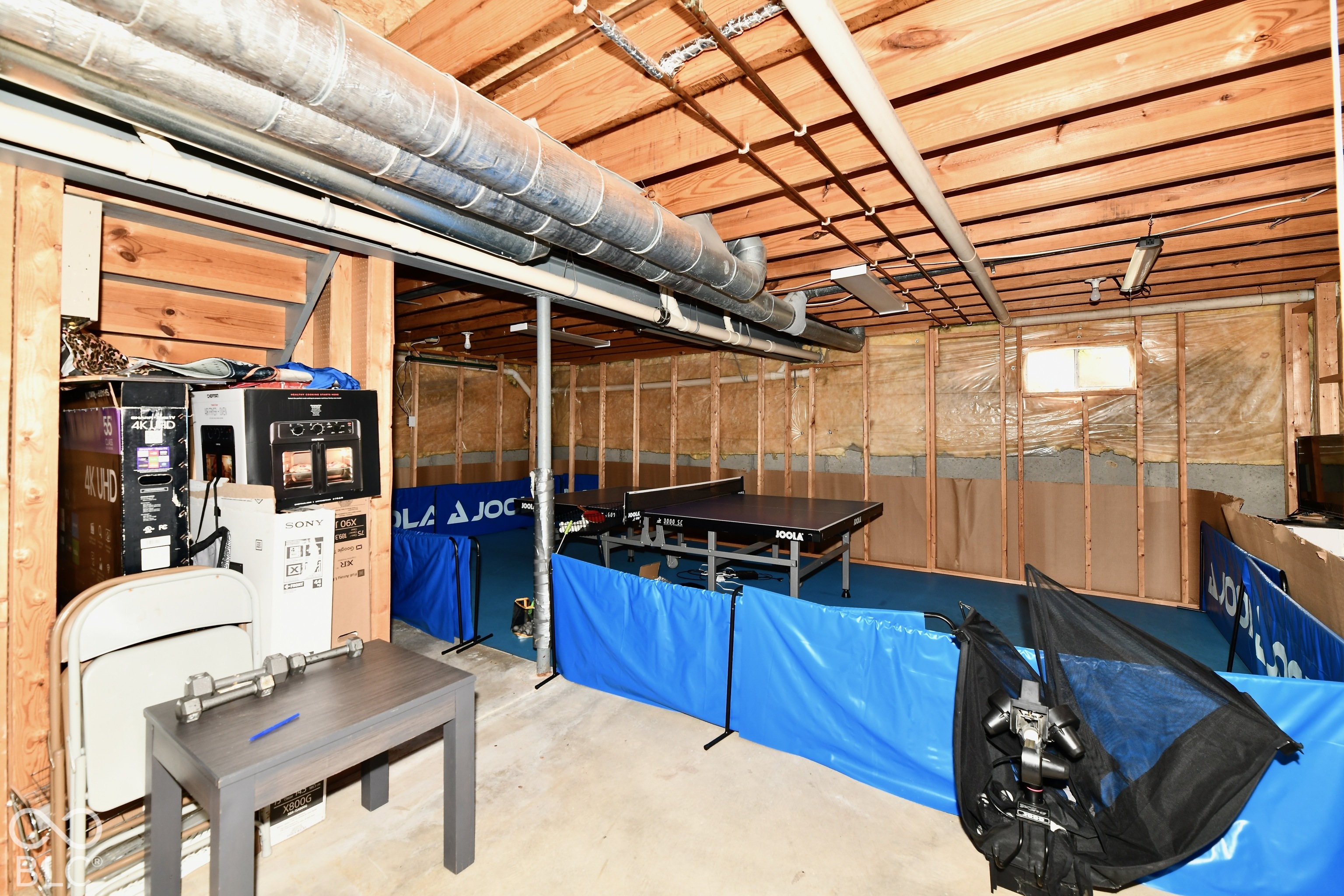 Unfinished basement level featuring exposed wood-joist ceiling, concrete foundation walls, support columns, and structural metal ductwork
