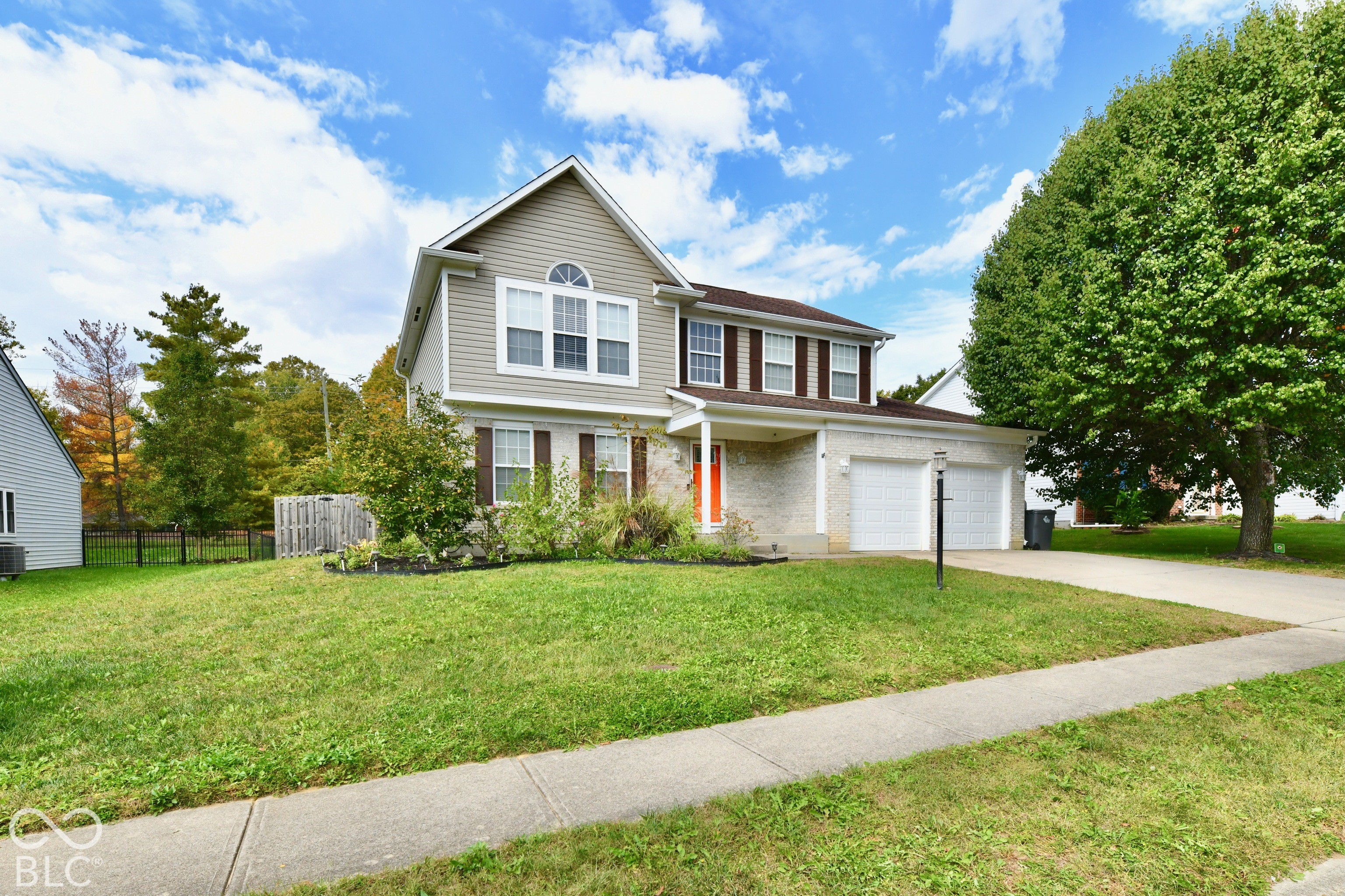 Two-story exterior featuring light-toned masonry and horizontal siding, double-car garage, and a covered front entry Two-story exterior featuring light-toned masonry and horizontal siding, double-car garage, and a covered front entry