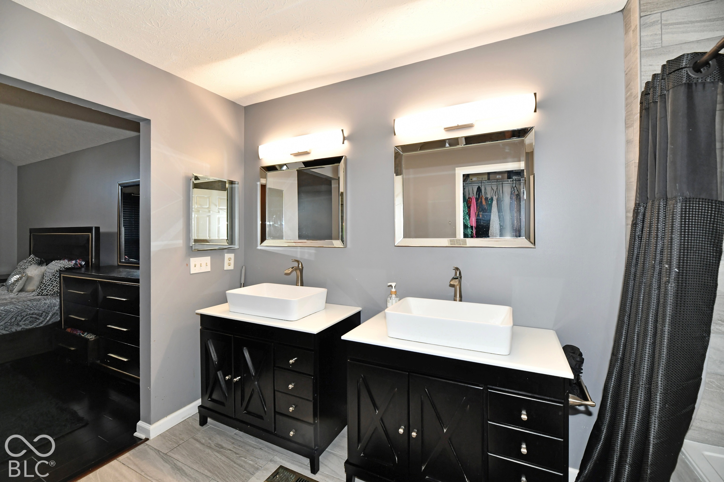 Dual vanity featuring dark cabinetry, rectangular vessel sinks, white countertops, wall-mounted rectangular mirrors, and horizontal lighting fixtures