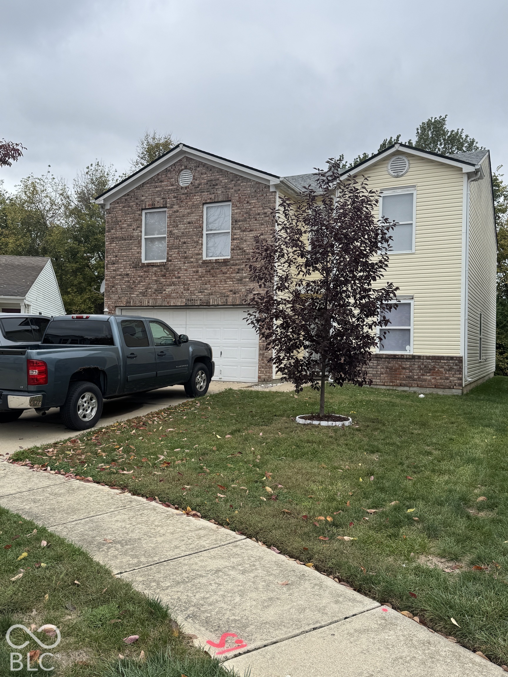 Two-story residence featuring a combination of stone veneer and horizontal siding, an attached two-car garage, and concrete walkway Two-story residence featuring a combination of stone veneer and horizontal siding, an attached two-car garage, and concrete walkway